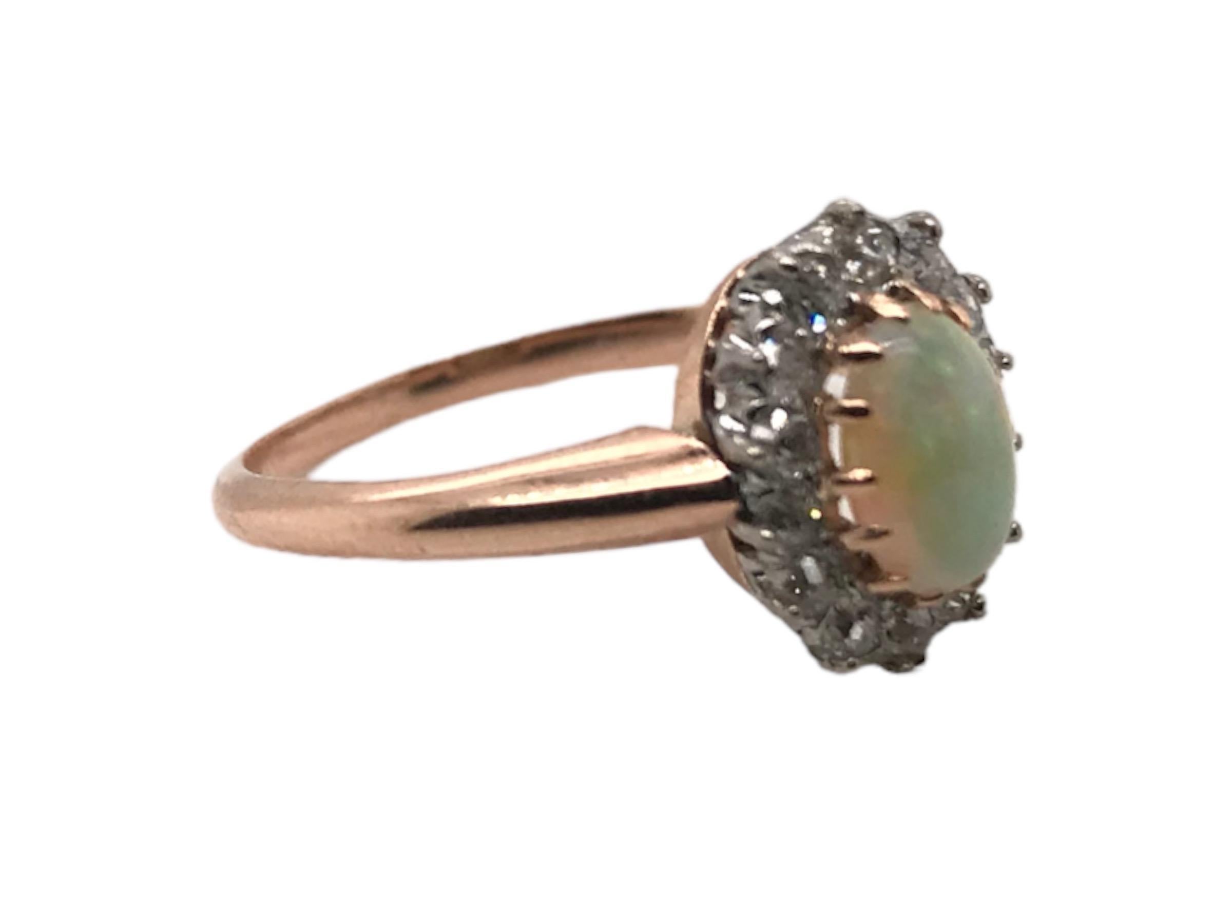 Nous aimons toujours les vieux anneaux de halo taillés à la mine !
Cette beauté est composée d'une opale vibrante qui présente une belle combinaison de bleu, de vert et de rouge. 
La pierre principale est rehaussée d'un ensemble de diamants de