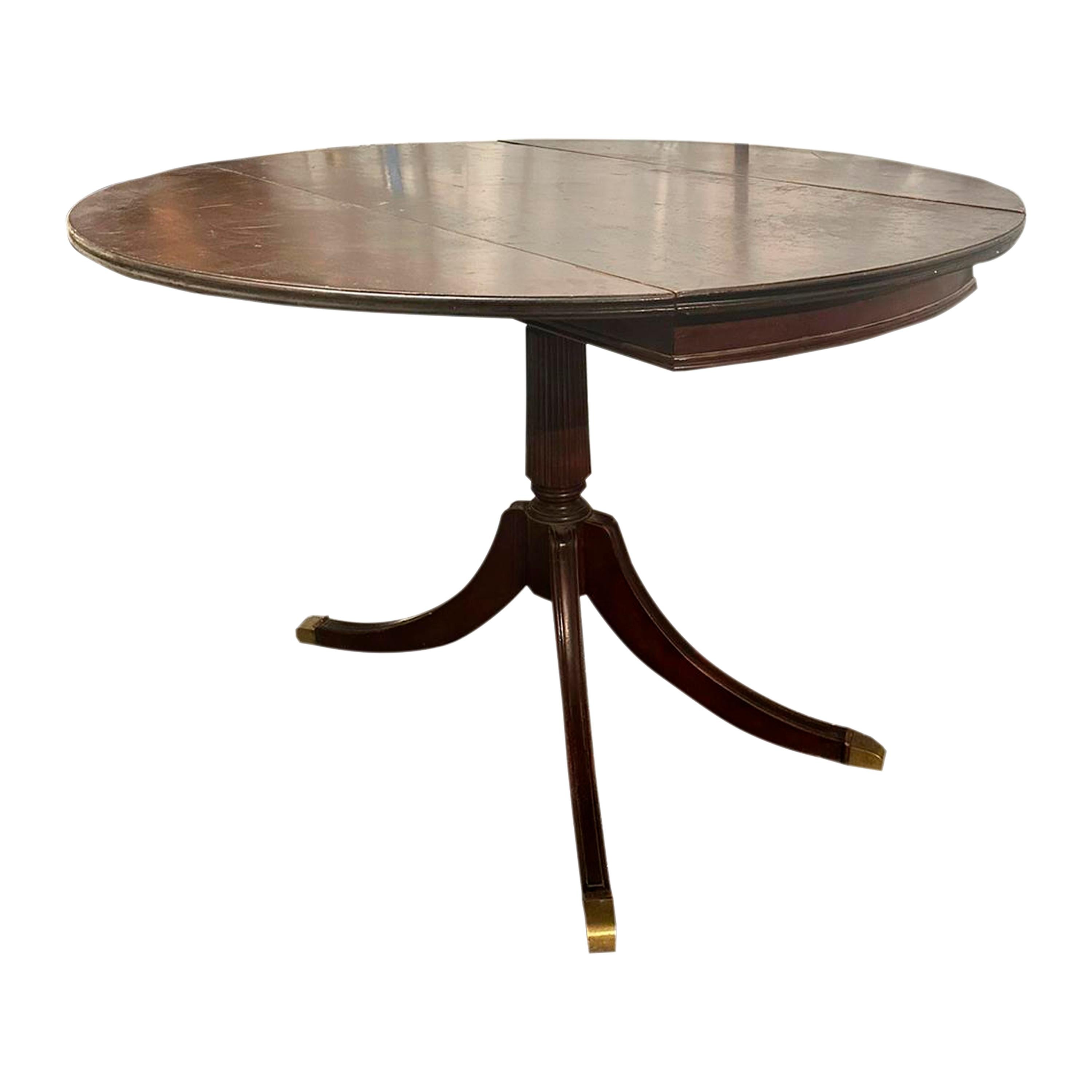 Table de salle à manger extensible ronde victorienne. Il est fabriqué en acajou massif et se compose d'une partie centrale qui repose sur un pied sculpté, lequel s'ouvre à son tour sur quatre pieds terminés par des griffes en bronze. Époque