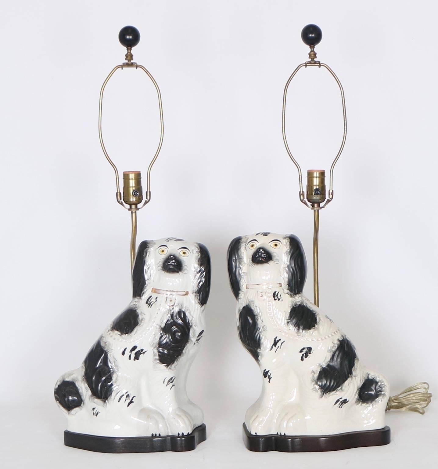 Pair of late 19th century Victorian era Stafforshire porcelain dogs, hand-painted in black and white with gilding to the collars. No marks present. These were made into lamps sometime in the 20th century. Each is in excellent antique condition