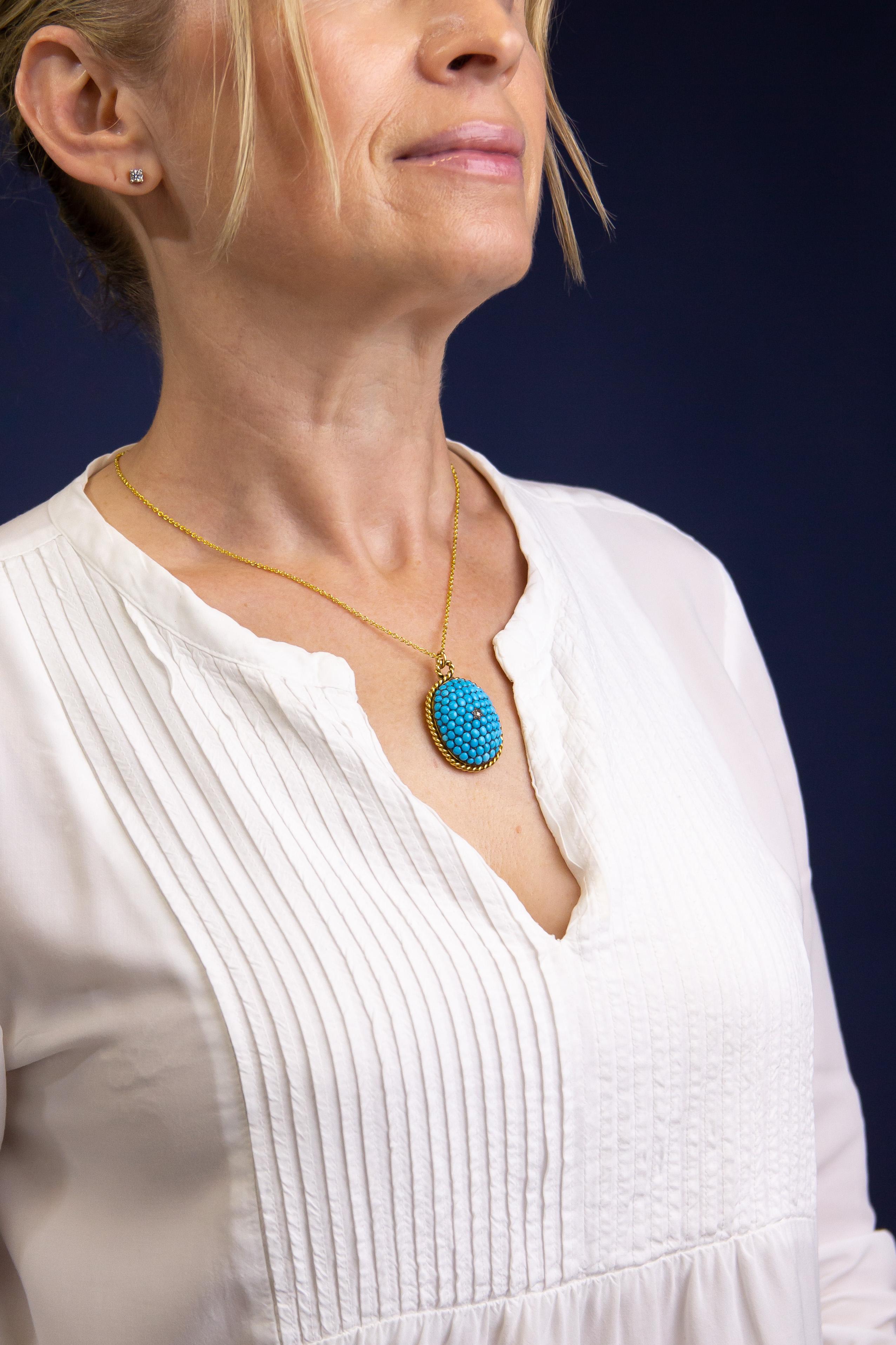 Dieser bezaubernde Medaillon-Anhänger stammt aus der viktorianischen Zeit. Er wurde aus 18 Karat Gelbgold gefertigt und mit einem Türkis-Cabochon und einem zentralen Diamanten besetzt. Im Mittelpunkt des ovalen Anhängers steht ein einzelner Diamant