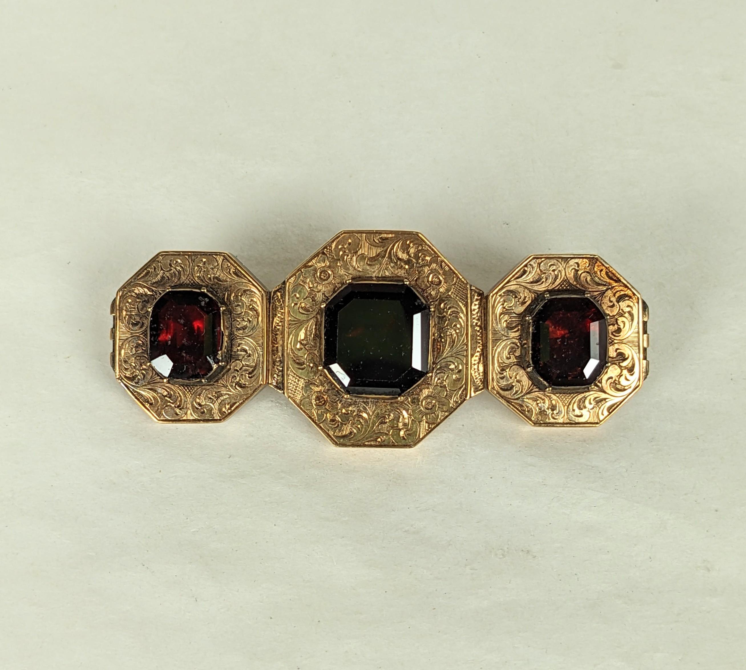 Victorian Etched Gold Garnet Brooch which was converted from a bracelet into a brooch circa 1910. Early 14K gold hand etched setting with octagonal cut foiled garnets which has been stabilized onto a gold backing inscribed with initials and date
