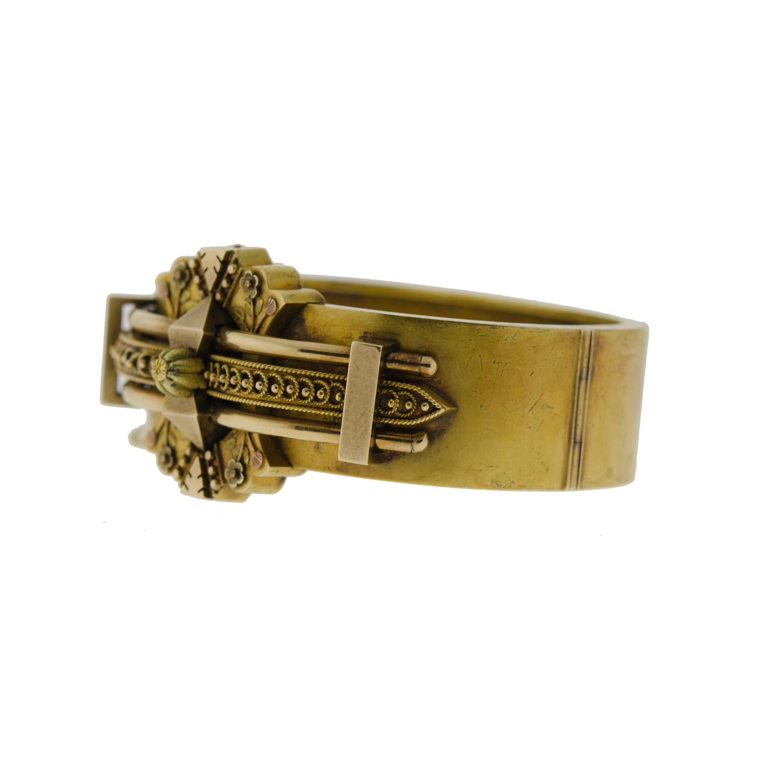 This striking multidimensional Victorian wide hinged bangle bracelet derives from the late nineteenth century. Handcrafted in 14 kt yellow gold and embellished with a classic Etruscan design. Applied goldwork covers the top of this bracelet,