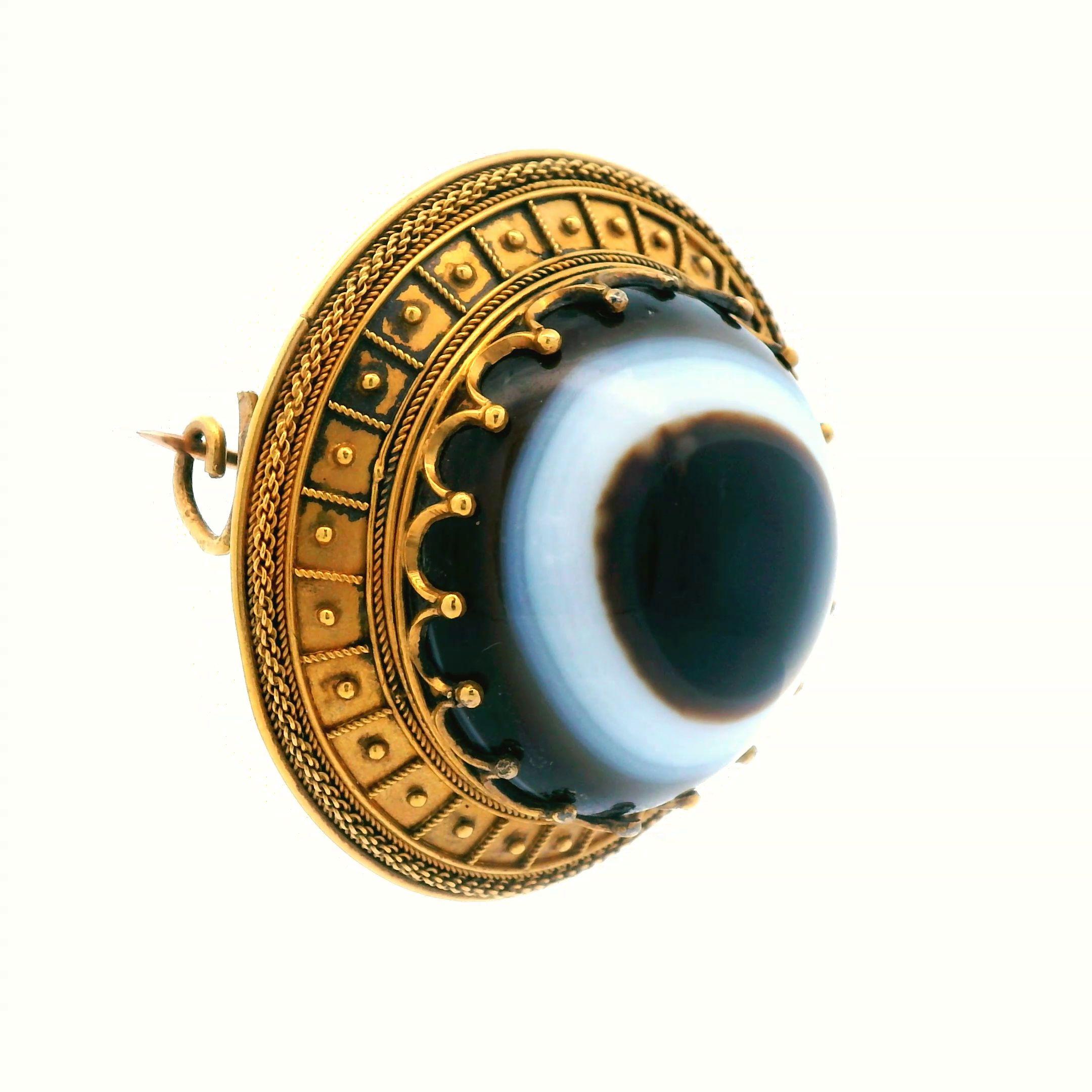 This lovely Victorian Etruscan pin is made in 18k yellow gold and features agate  EYE with a papal mark. The pin is 1.5 inches around and has a gram weight of 15.39 grams making this pin feel solid, yet still light weight enough to wear all day and