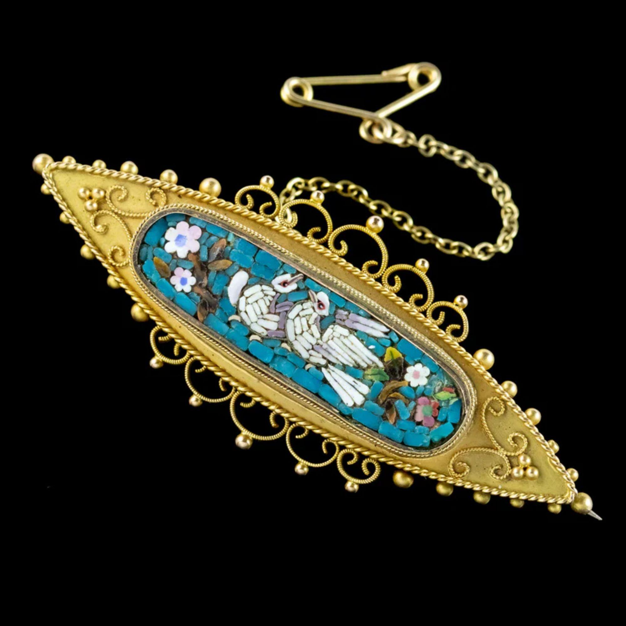 An exquisite antique mid-Victorian Etruscan revival brooch (Circa 1870) featuring a detailed Micro Mosaic centre piece depicting flowers and two white doves upon a blue backdrop. 

Roman style Micro Mosaic's such as this are made up of unusually