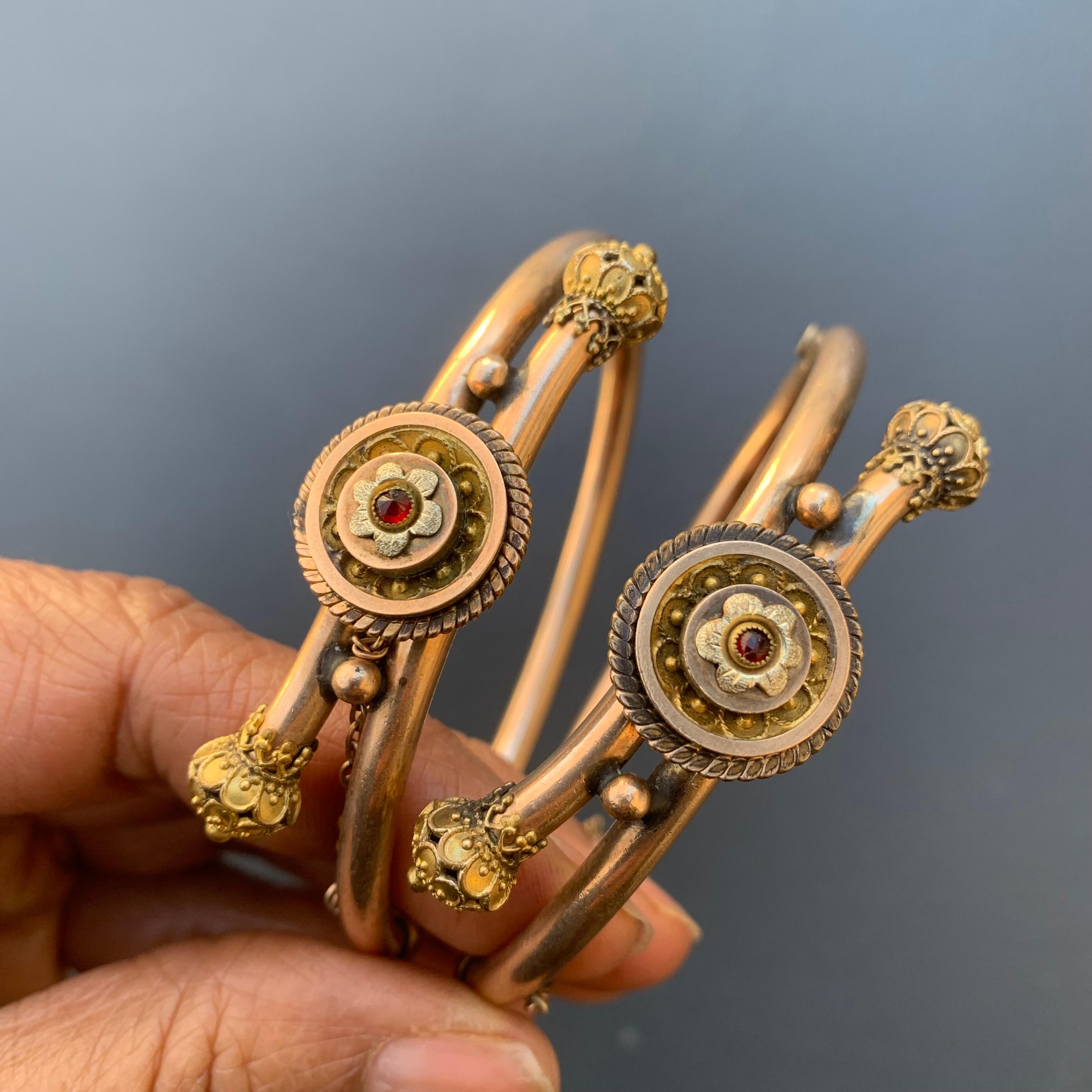 rare collectible Antique Victorian Etruscan Revival rose gold filled wedding bangle set of 2 . Each hinged bangle has applied wire and bead work with a garnet stone in center . Bangles are in two shades rose gold and yellow gold ends . Hidden tongue