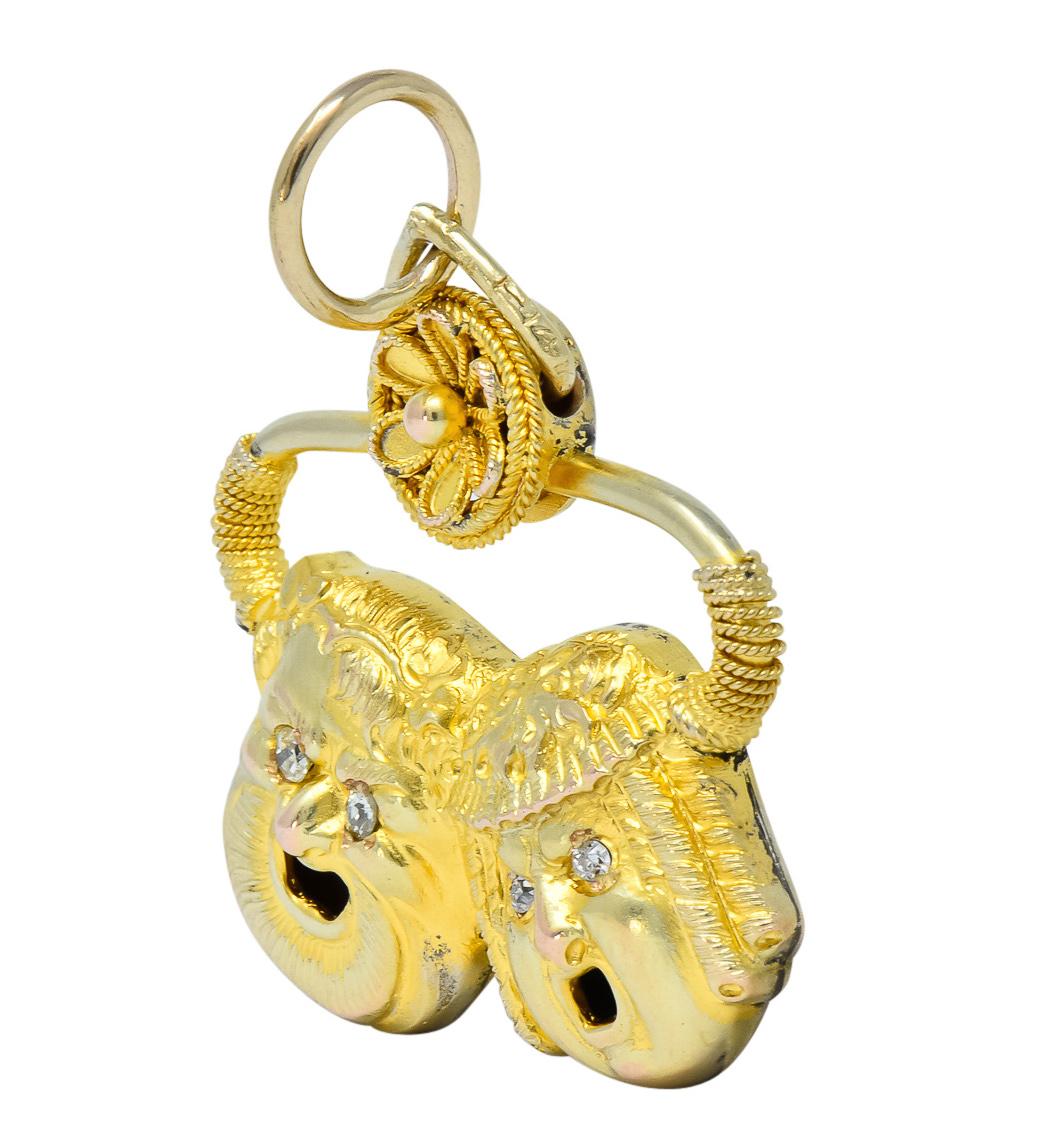 Pendant featuring comedy and tragedy masks with deeply engraved stylized hair details and decorated throughout with coiled rope motif

Accented by single and Swiss cut diamonds for eyes, eye-clean and white

Topped by dainty flower with gold bead