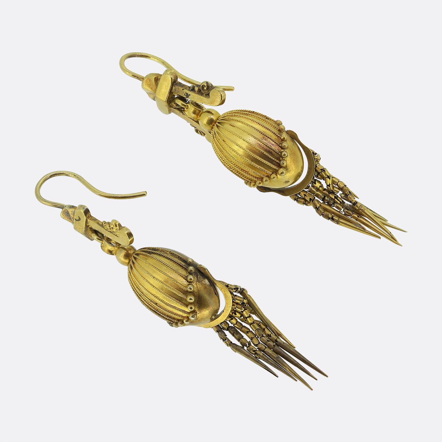Here we have a delightful pair of Victorian drop earrings. Each identical piece has been crafted from a rich 18ct yellow gold in an Etruscan style and feature an egg shaped centre decorated with roped lining and beaded endings. At the bottom of both