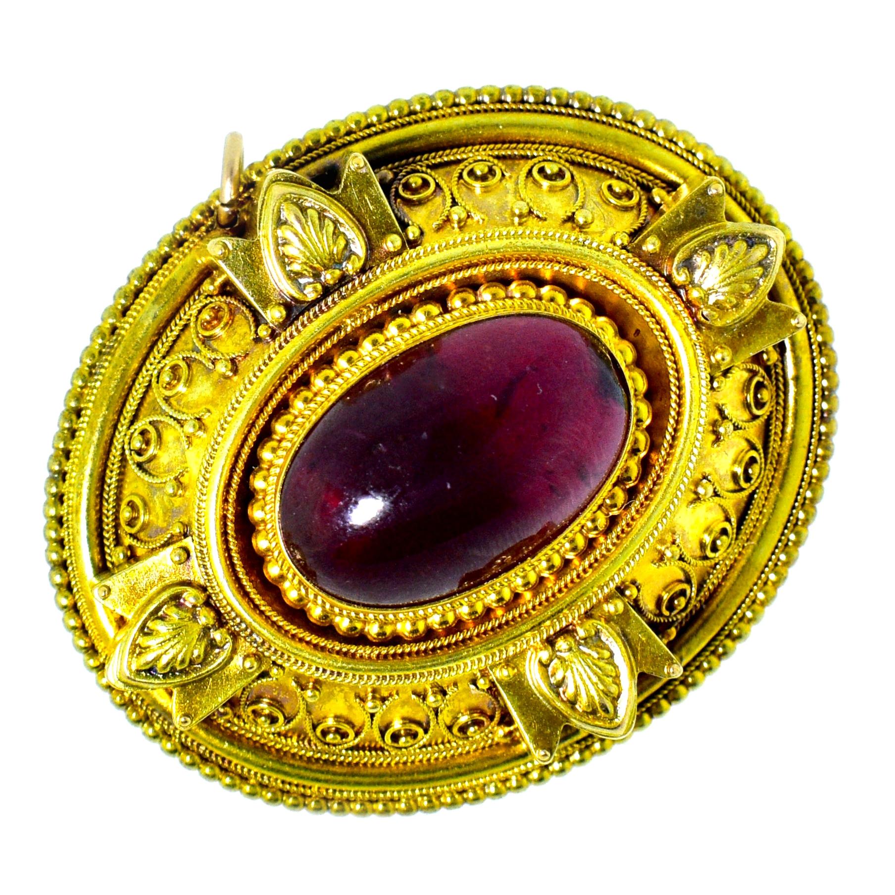 Etruscan, from the last quarter of the Nineteenth Century, large gold antique brooch centering a carbuncle natural garnet weighing approximately 9 cts., and surrounded by fine bead and wire work, Etruscan Revival.  On the verso, is the original hair