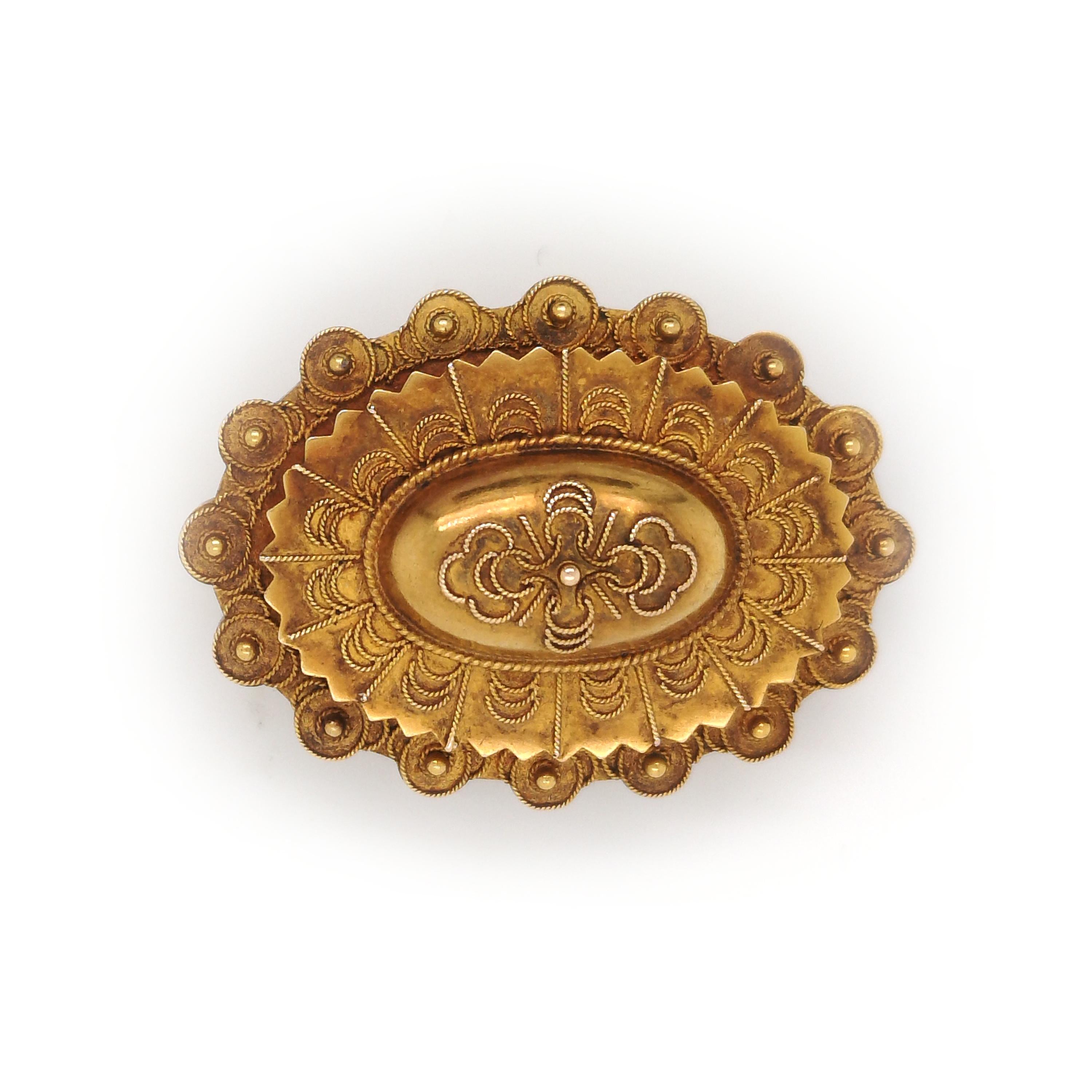A Victorian, Etruscan style brooch and earrings suite, comprising an oval brooch, with three layers, with a central dome, all decorated with Etruscan style wire work, with a loop on the back for hanging a pendant and a pin and hook catch,