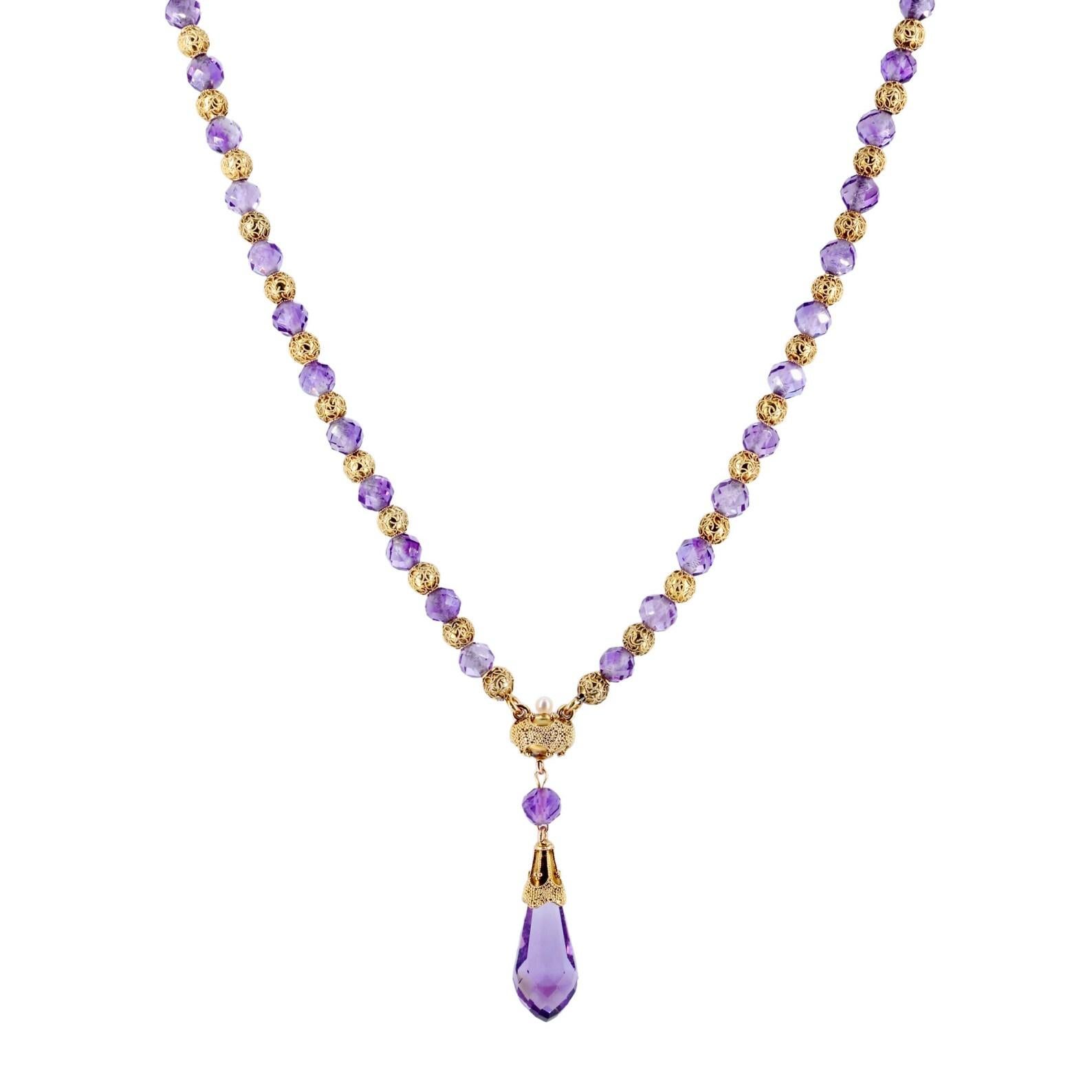 A victorian period amethyst, and gold bead drop necklace. Centered by a briolette cut amethyst pendant, suspended from a beautifully embellished gold mount. Framed by alternating faceted amethyst beads, and embellished beads of rich 18 karat gold.
