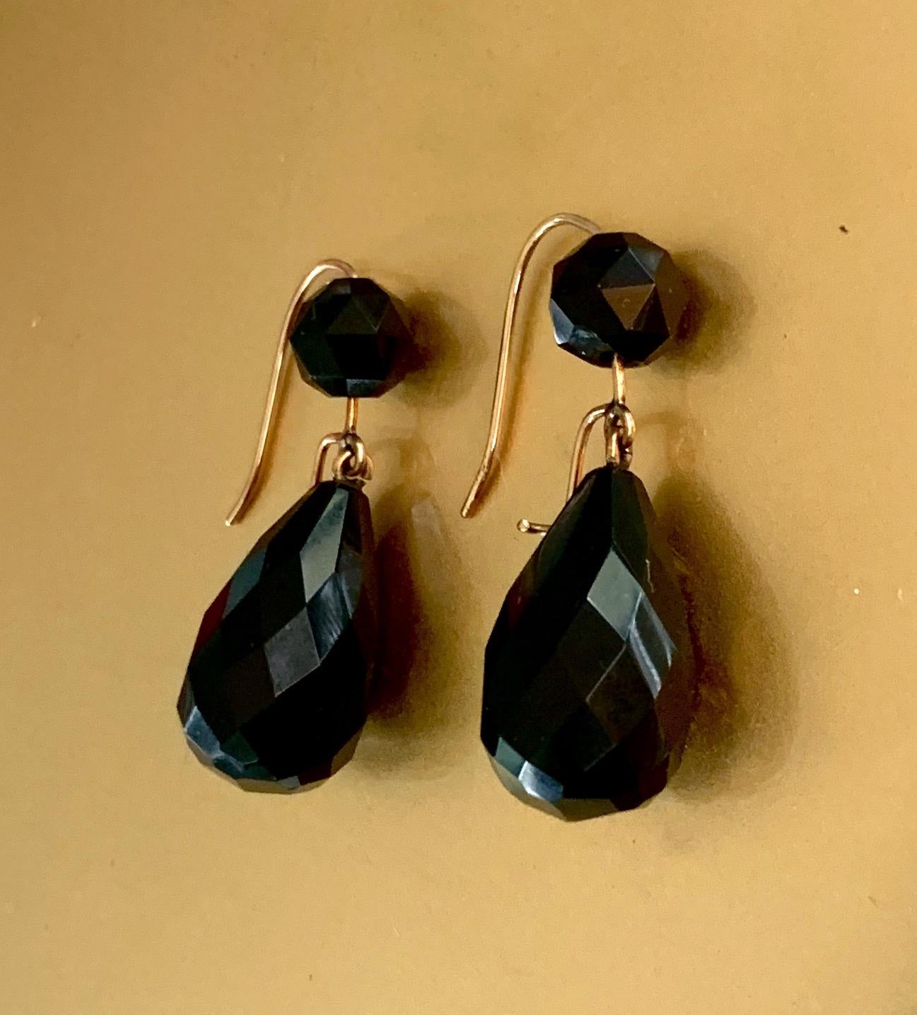These lovely earrings feature two black Onyx stones in each earring. One is a round faceted stone and one is tear dropped-shaped faceted stone.  The wires are Gold. 
Length:  1 1/2