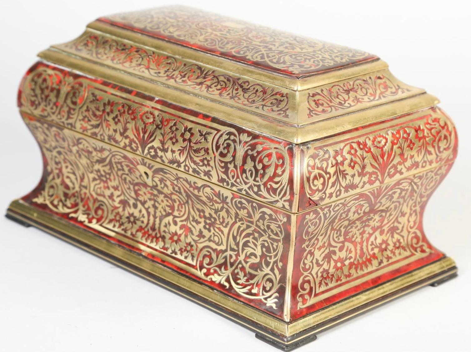 Buzón tipo cofre boulle del siglo XIX, de Halstaff y Hannover. El exterior está acabado con incrustaciones ornamentales de boulle en todos los lados en dorado y rojo. Un delicado ribete de latón y un escudo incrustado en la caja boulle. Cuando se