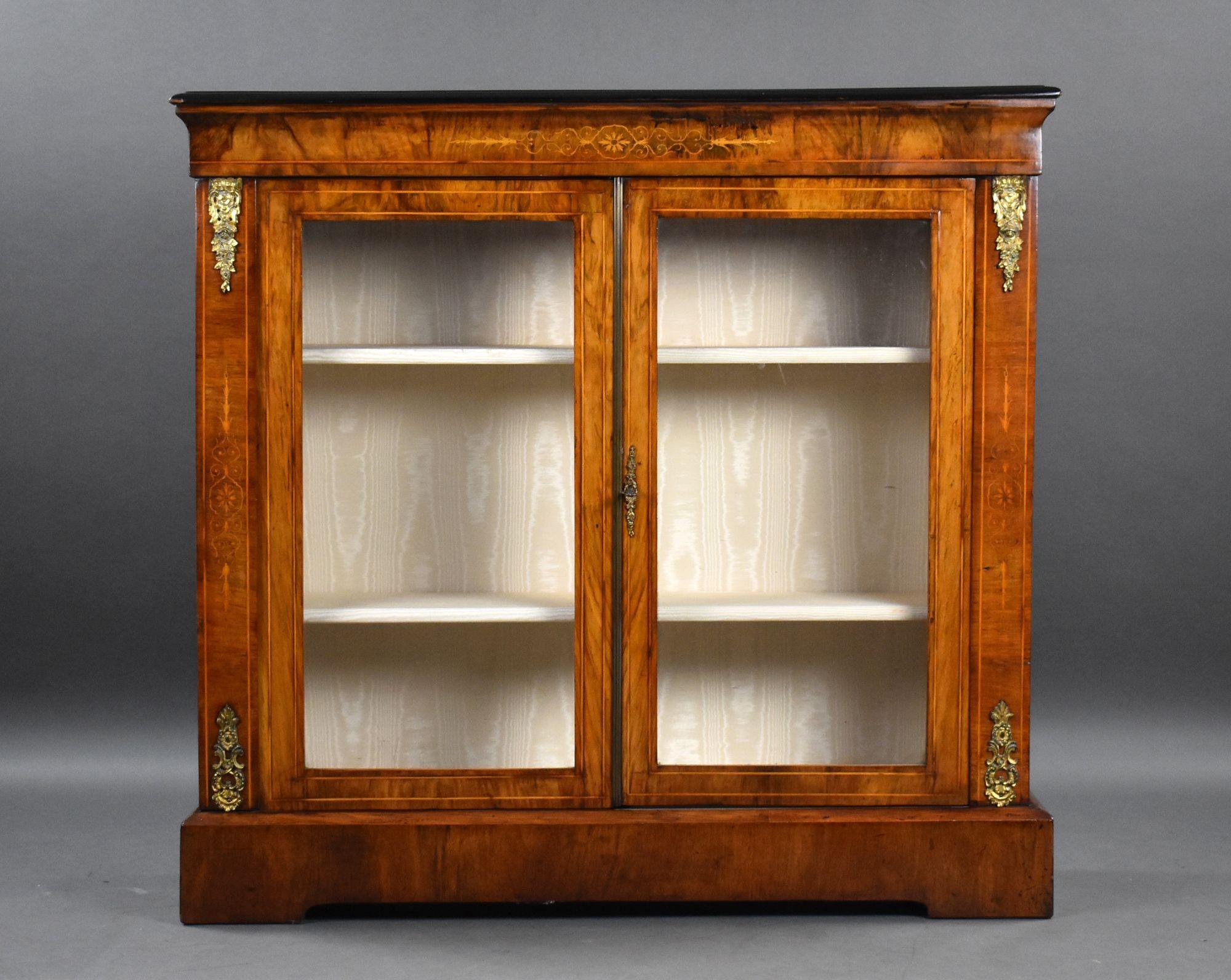 For sale is a Victorian figured walnut pier cabinet, inlaid throughout with decorative gilt mounts, the cabinet has two glazed doors opening to a fabric lined interior, raised on a plinth base, the cabinet remains in very good condition, showing