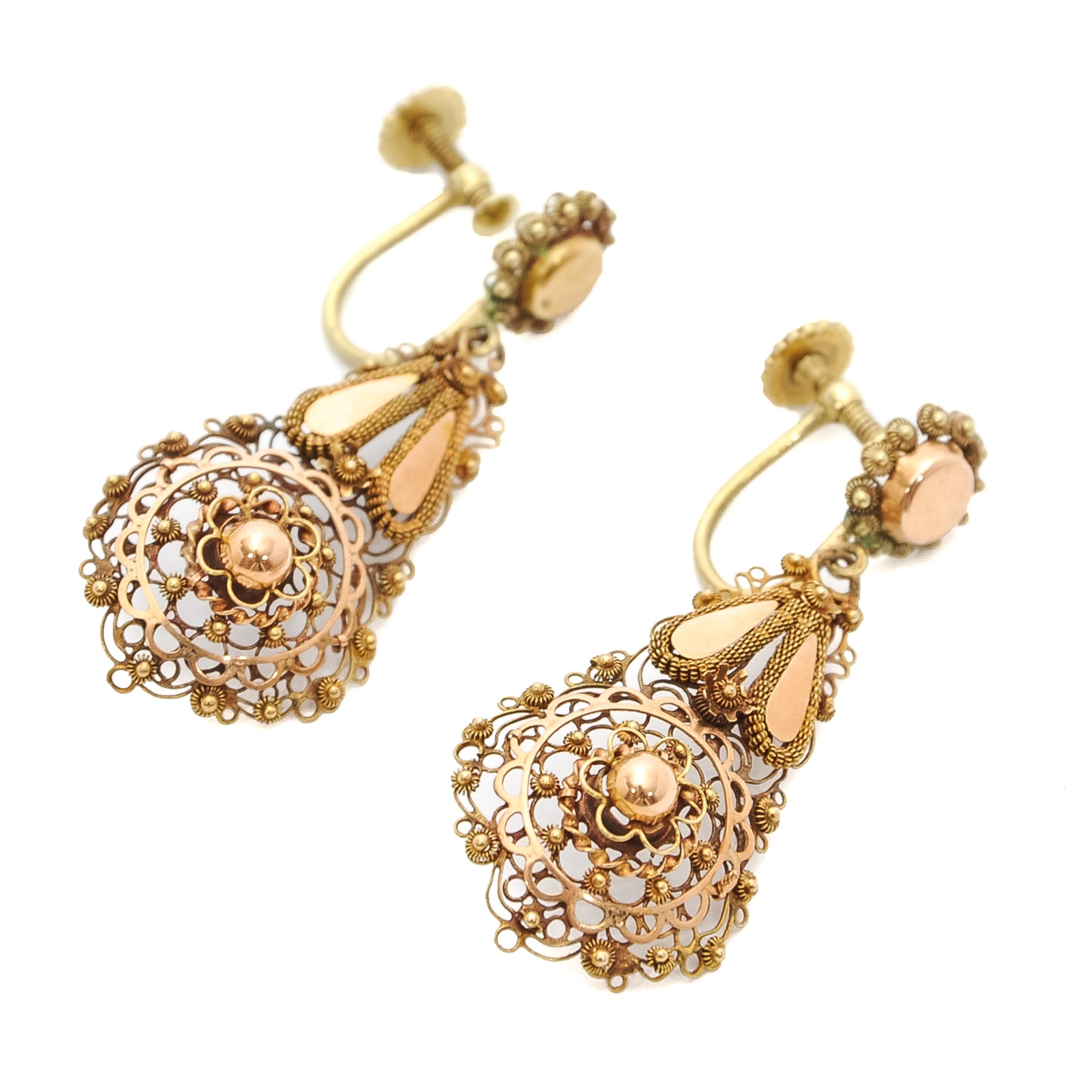 These antique 14 karat rose gold dangle earrings are beautifully handcrafted with an openwork filigree and cannetille work design. The earrings are skillfully handcrafted which gives the impression of fine lace. They are characterized by their