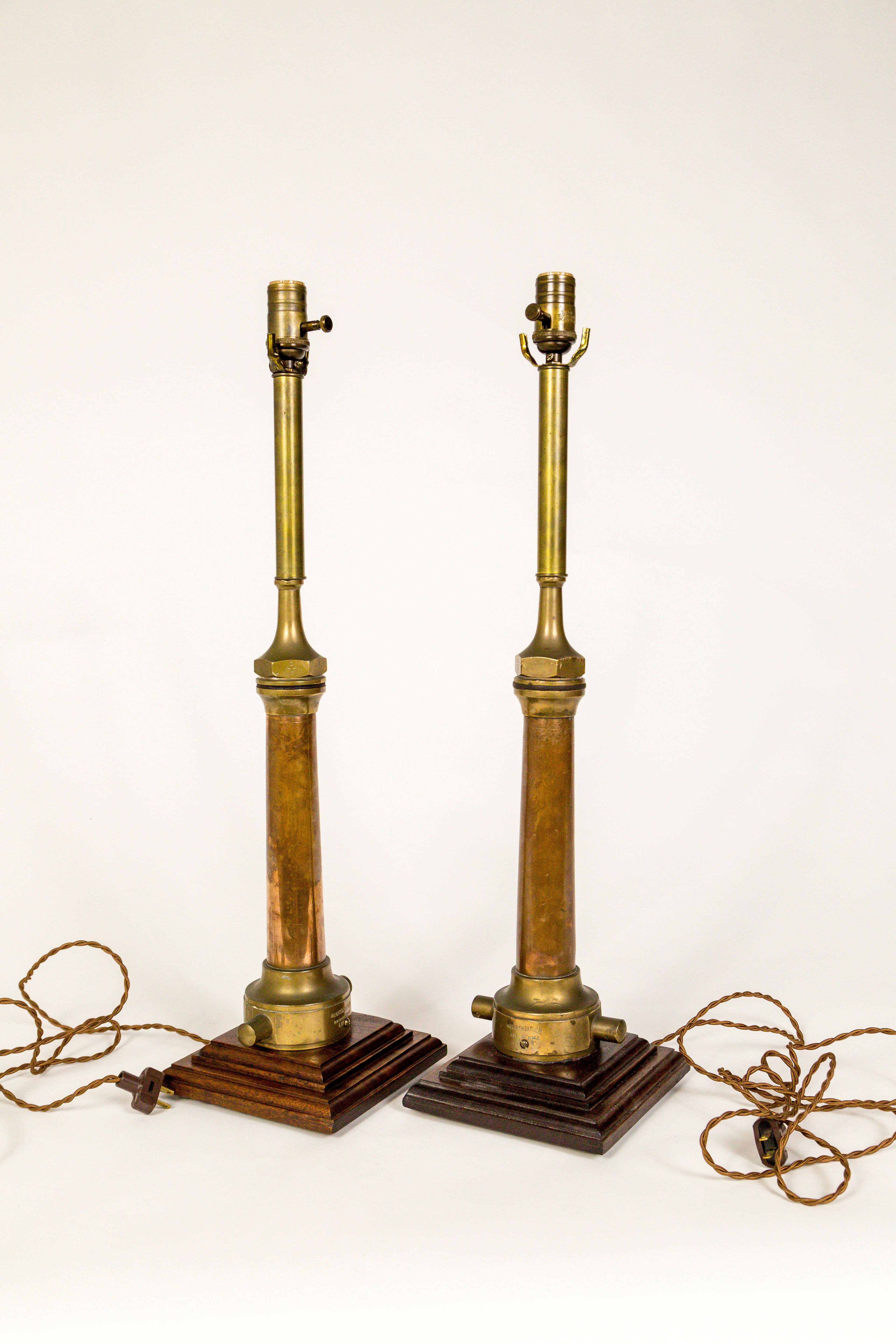A handsome pair of table lamps made from antique, copper and brass, Victorian fire hose nozzles on walnut wood bases. Imprinted 