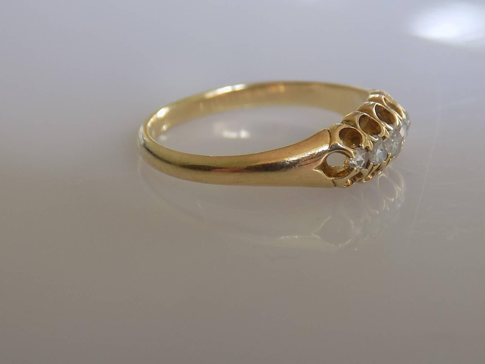  A Lovely Victorian c.1880s 18 Carat Gold and five Rose cut Diamond ring. English origin.
Size L 1/2 UK, 6.25 US (sizeable).
Height of the face 5.5mm.
Diamonds from 1.5mm to 2.5mm
Weight 2.1gr.
Marked 18 for 18 carat gold.
The ring in very good