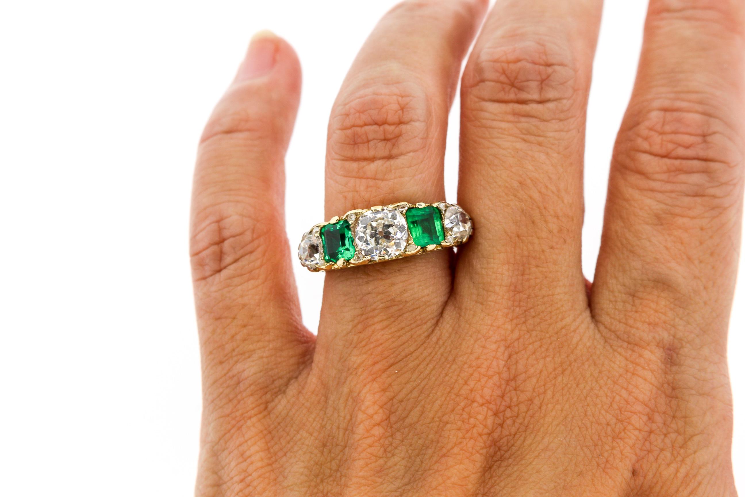 A bright Victorian emerald and Old Mine cut diamond half hoop five stone ring dating to about 1880. The ring centers on an Old Mine cut diamond weighing approximately 1.15 carats that is graded as an I color and VS2 clarity. The two other diamonds