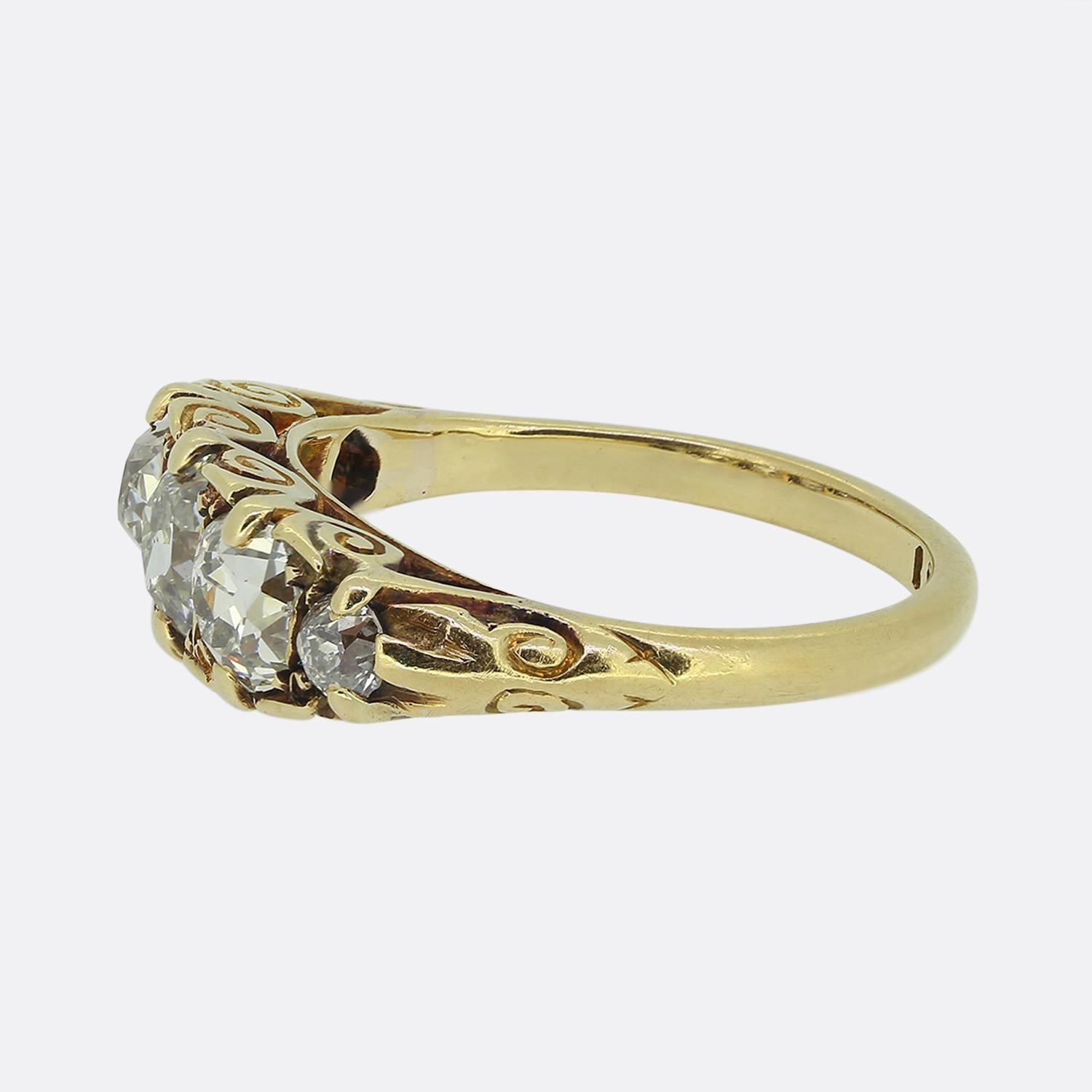 Nous avons ici une magnifique bague à cinq pierres en diamant datant de l'époque victorienne. Cette pièce ancienne a été fabriquée en or jaune 18 carats et présente trois grands diamants ronds facettés de taille ancienne au centre de la face, ainsi