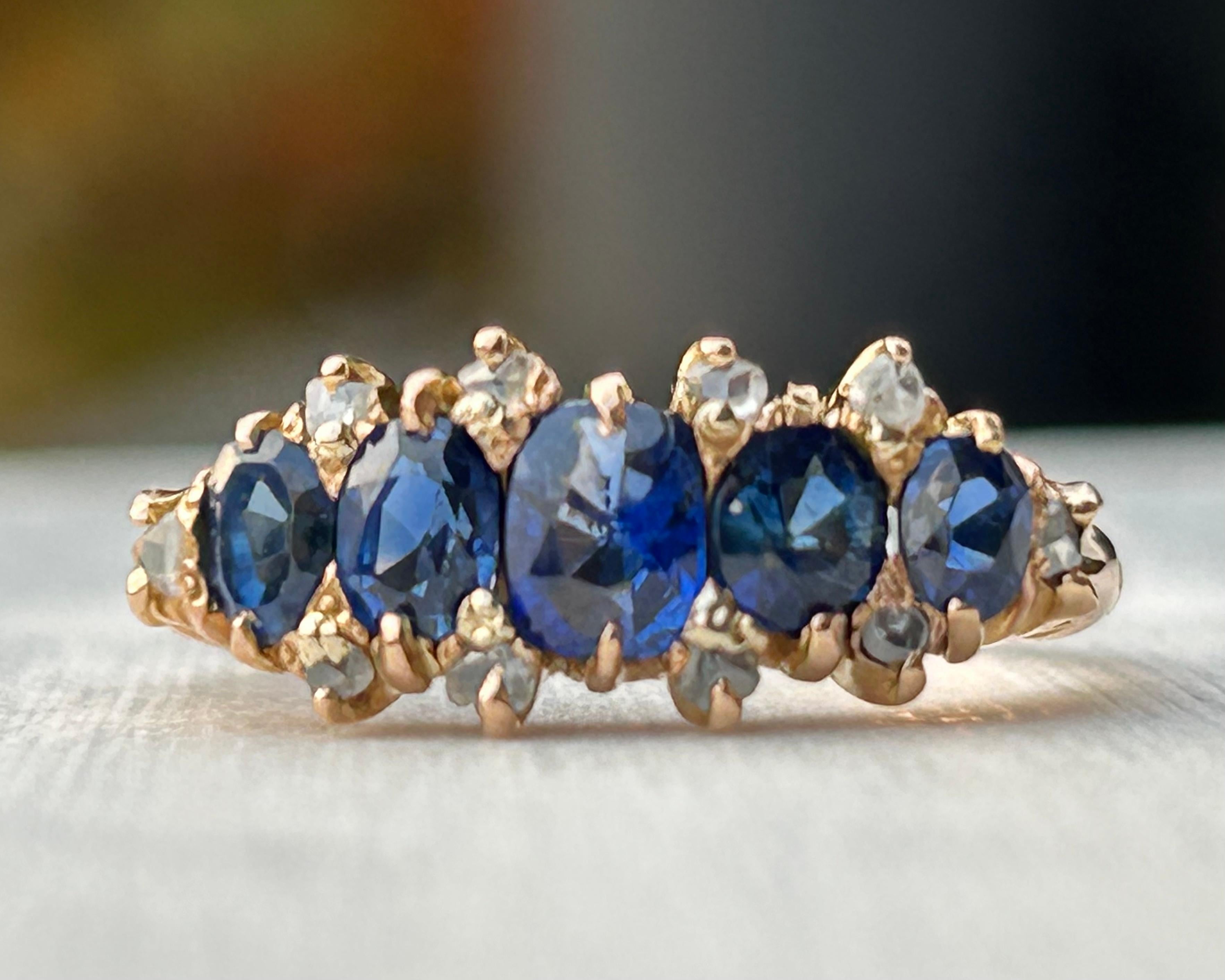 Handmade 18K rose gold, 5-stone vivid deep blue violet sapphire and rose cut diamond band. The band measures approximately 3.75mm at the shoulder, tapering to 1.45mm in width at the base, with stones spanning approximately 7.87mm in finger length.