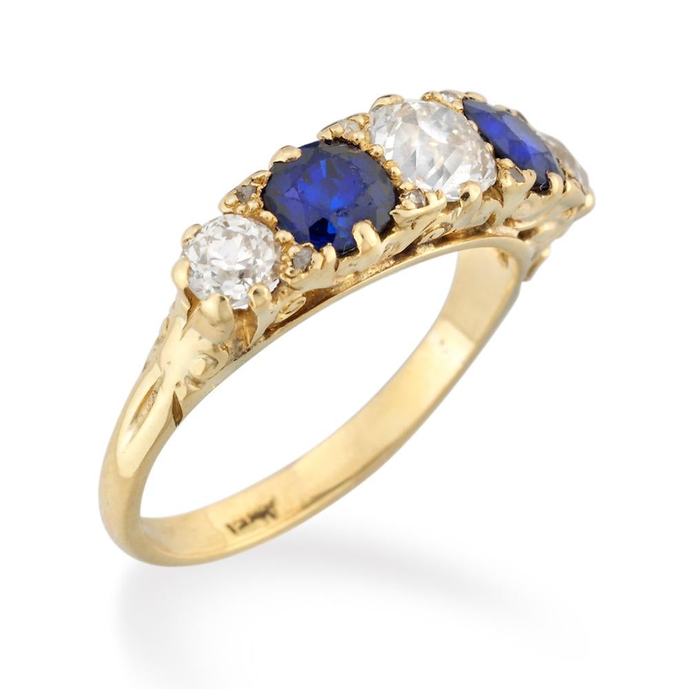 A Victorian five stone carved half hoop sapphire and diamond ring, set alternately with five graduated diamonds and sapphires, three old brilliant-cut diamonds estimated to weigh a total of 1.5 carats and two cushion shape faceted sapphires weighing