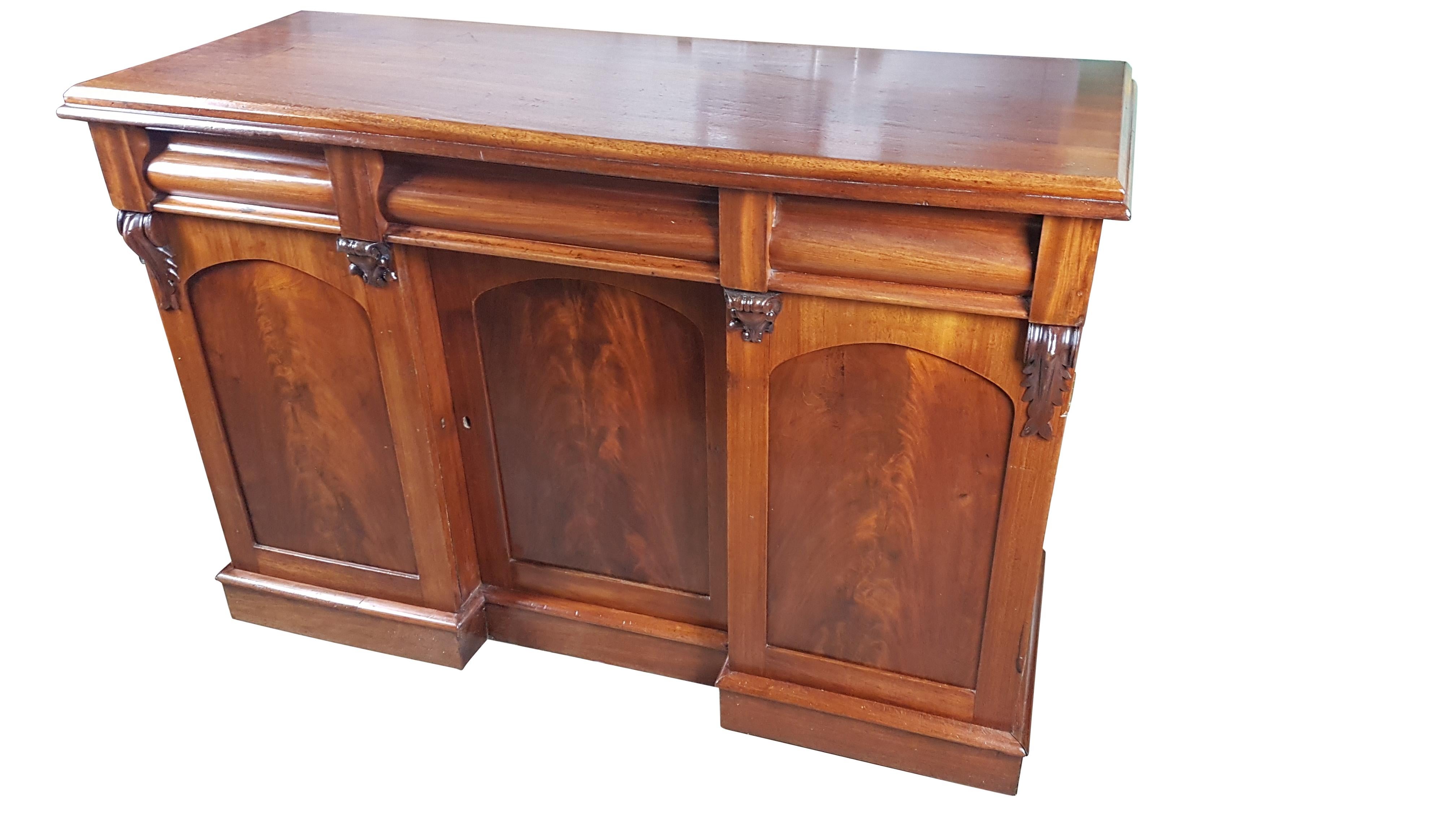 A nice petite solid mahogany Victorian sideboard with flame mahogany panels and inverted breakfront cupboards. The sideboard is in very good structural condition with the polish having recently been revived. There are marks and dents etc. but