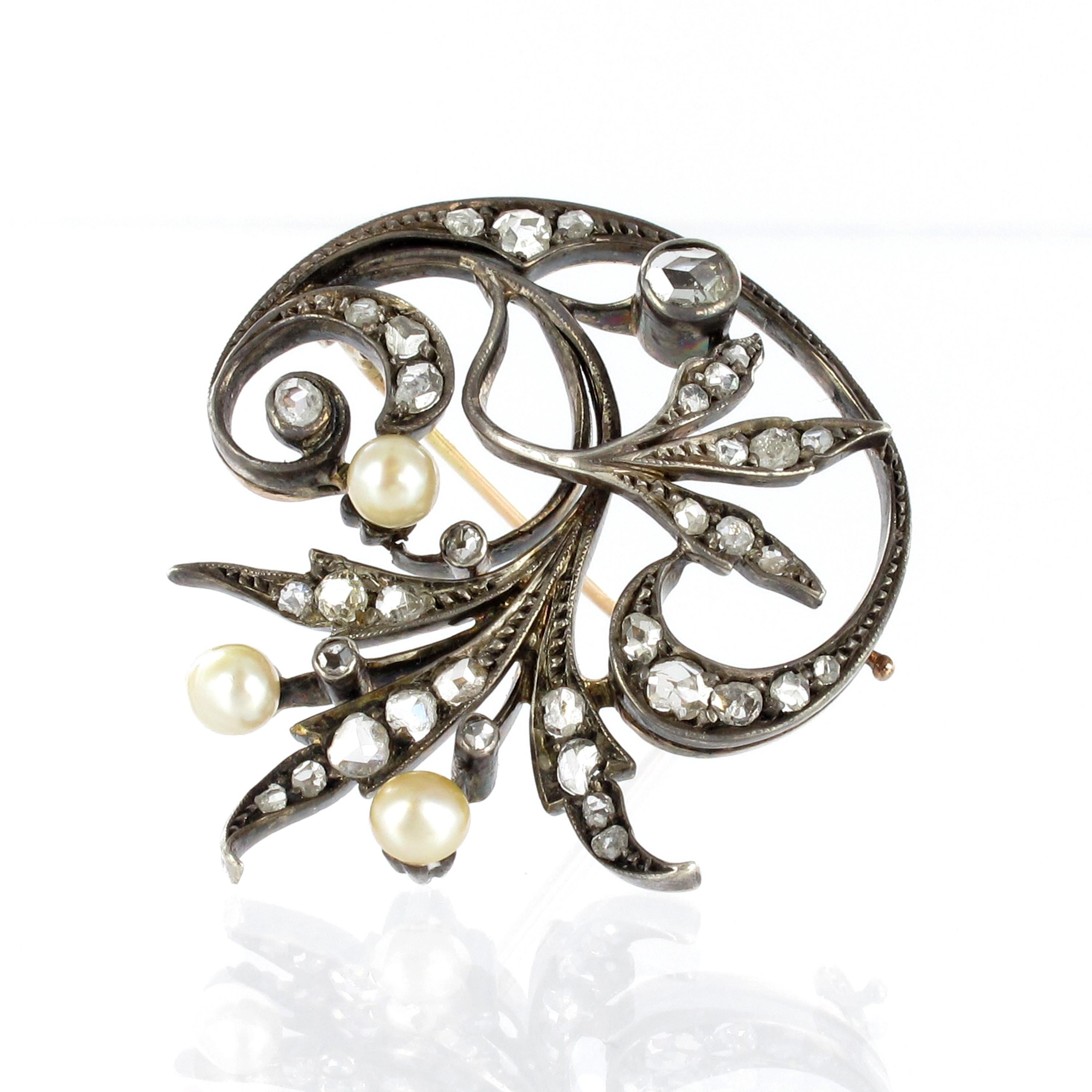 Victorian floral brooch in silver on 18K rose gold. The lovely brooch is set with three small natural pearls of   mm in size and 33 rose cut diamonds totalling approximate 0.75 ct.

Brooch system in 18K rose gold.

Dimensions: 35 x 30 mm / 1.38 x