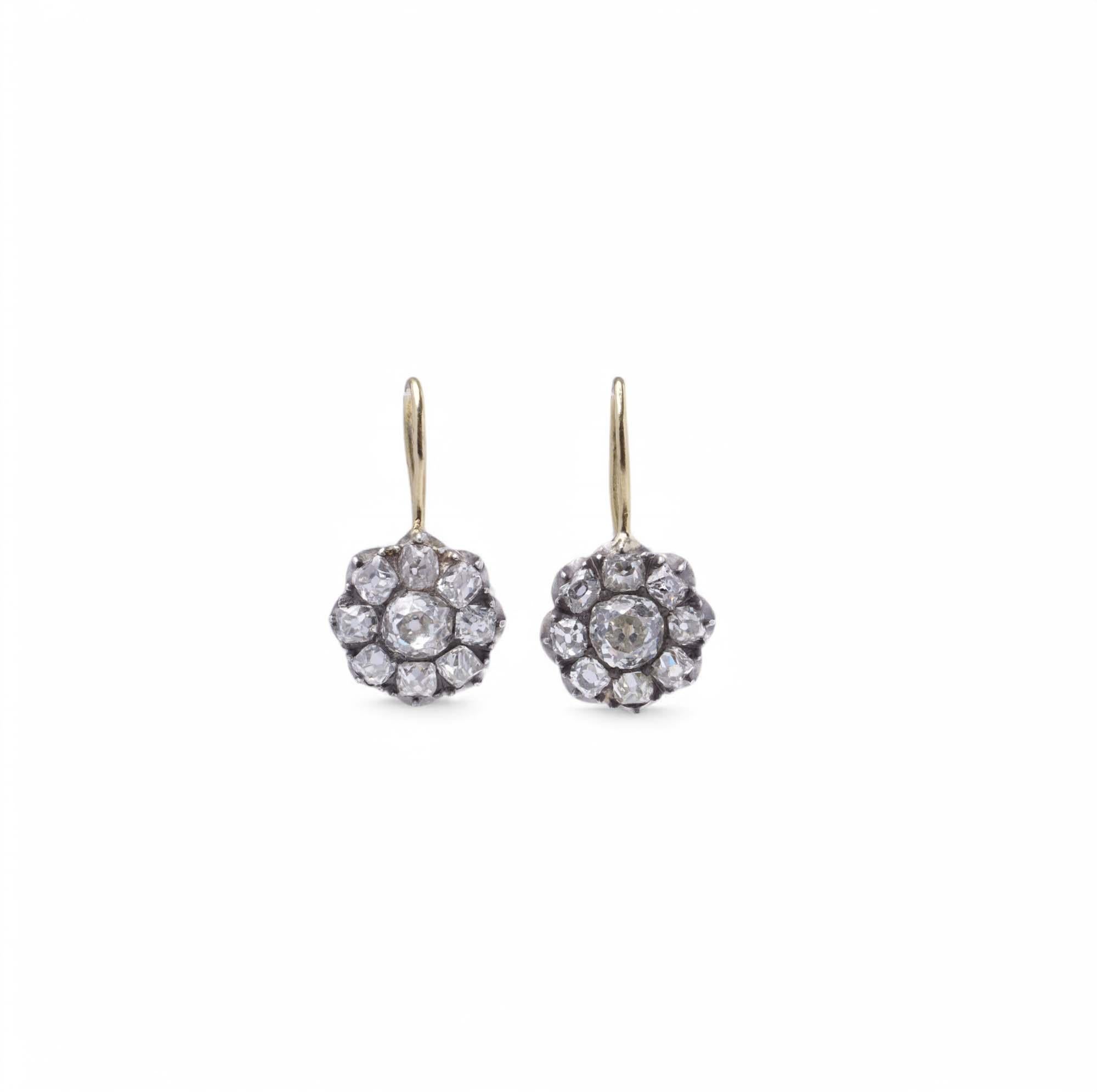 Estos exquisitos pendientes en forma de gota presentan un diseño clásico en racimo, engastado con un total de 18 diamantes brillantes, que crean un llamativo motivo floral. Los pendientes de 2,3 cm x 1,2 cm están finamente elaborados con delicados