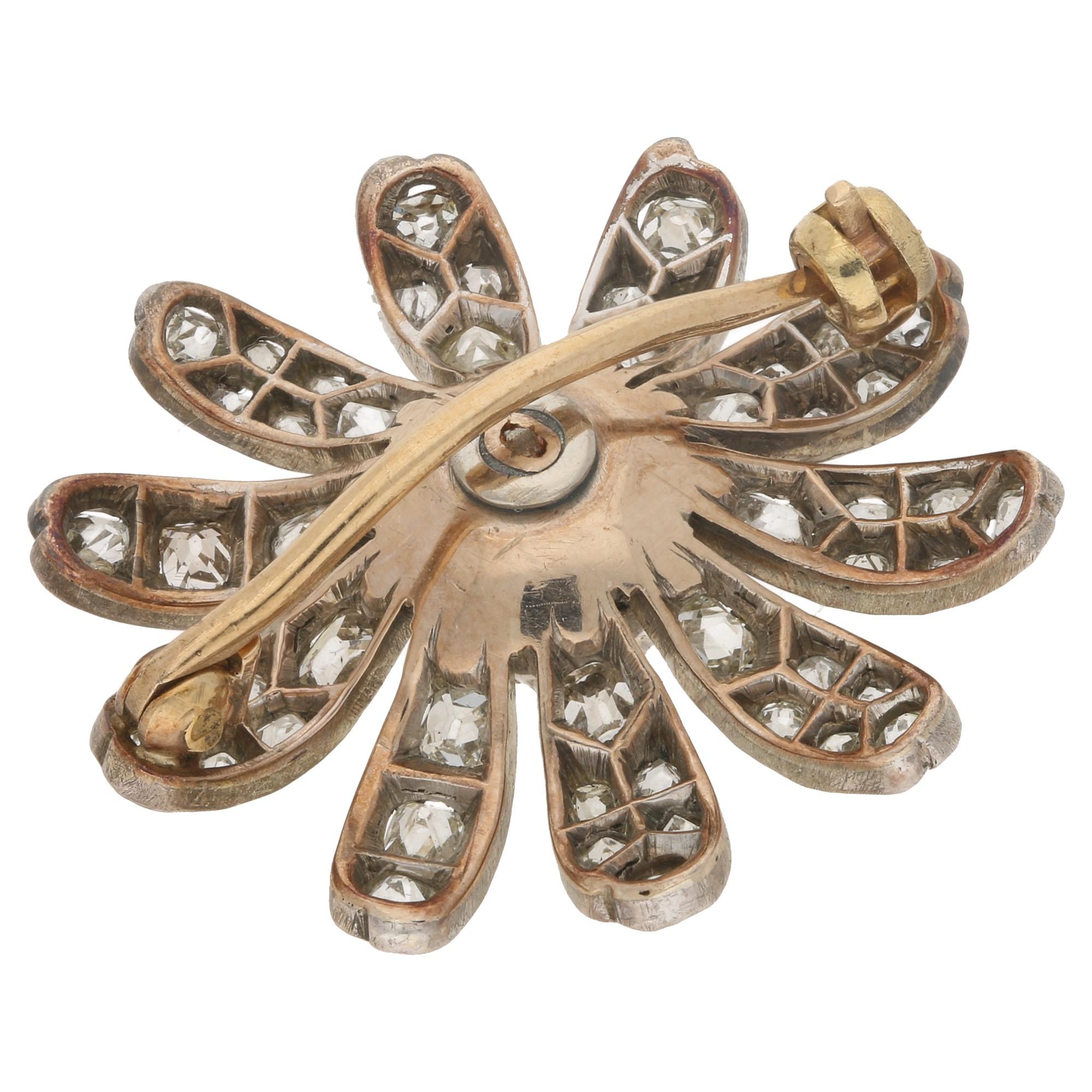 A beautiful late Victorian diamond flower brooch set in the distinctive Victorian silver on gold. 

The brooch is set with a mixture of eight cut and old mine cut diamonds within a beautifully intricate floral motif. It is secured to reverse with a