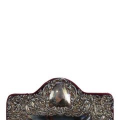 Espejo de tocador victoriano de plata de ley con motivos florales en repujado, hacia 1900