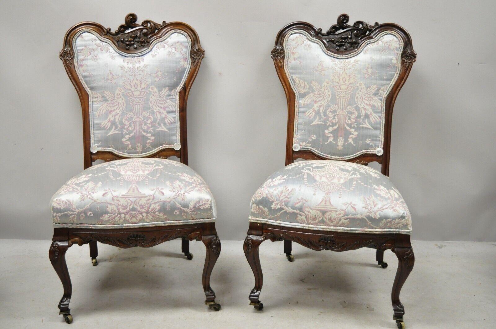 Antique Victorian Floral Scrollwork Carved Mahogany Parlor Slipper Side Chairs - a Pair. L'article présente un cadre sculpté de volutes florales, des roulettes en laiton, un cadre en bois massif, des dossiers rembourrés, des détails joliment