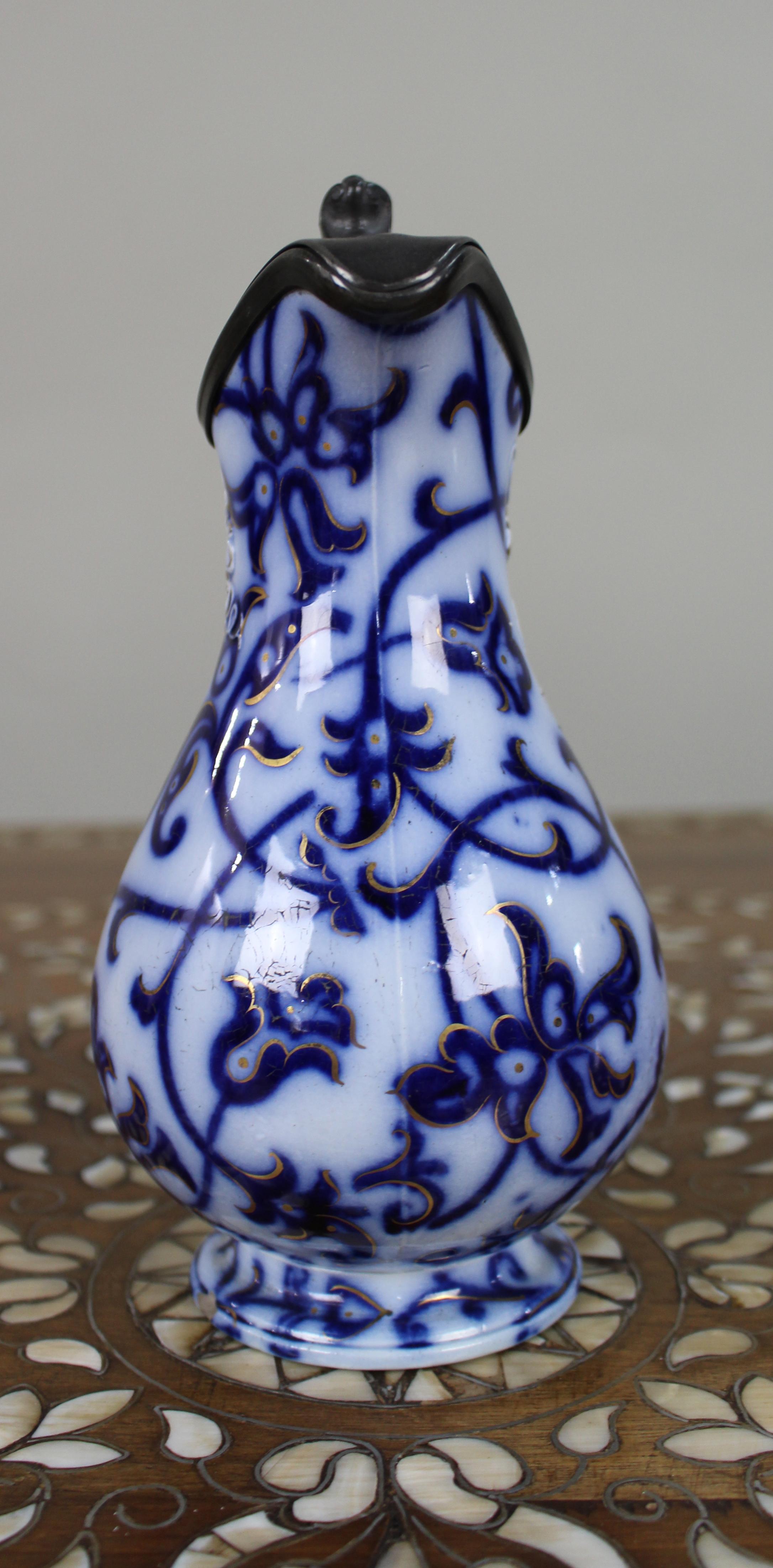 XIX secolo Brocca vittoriana Flow Blue modellata a rilievo con coperchio in peltro, 1850 ca. in vendita