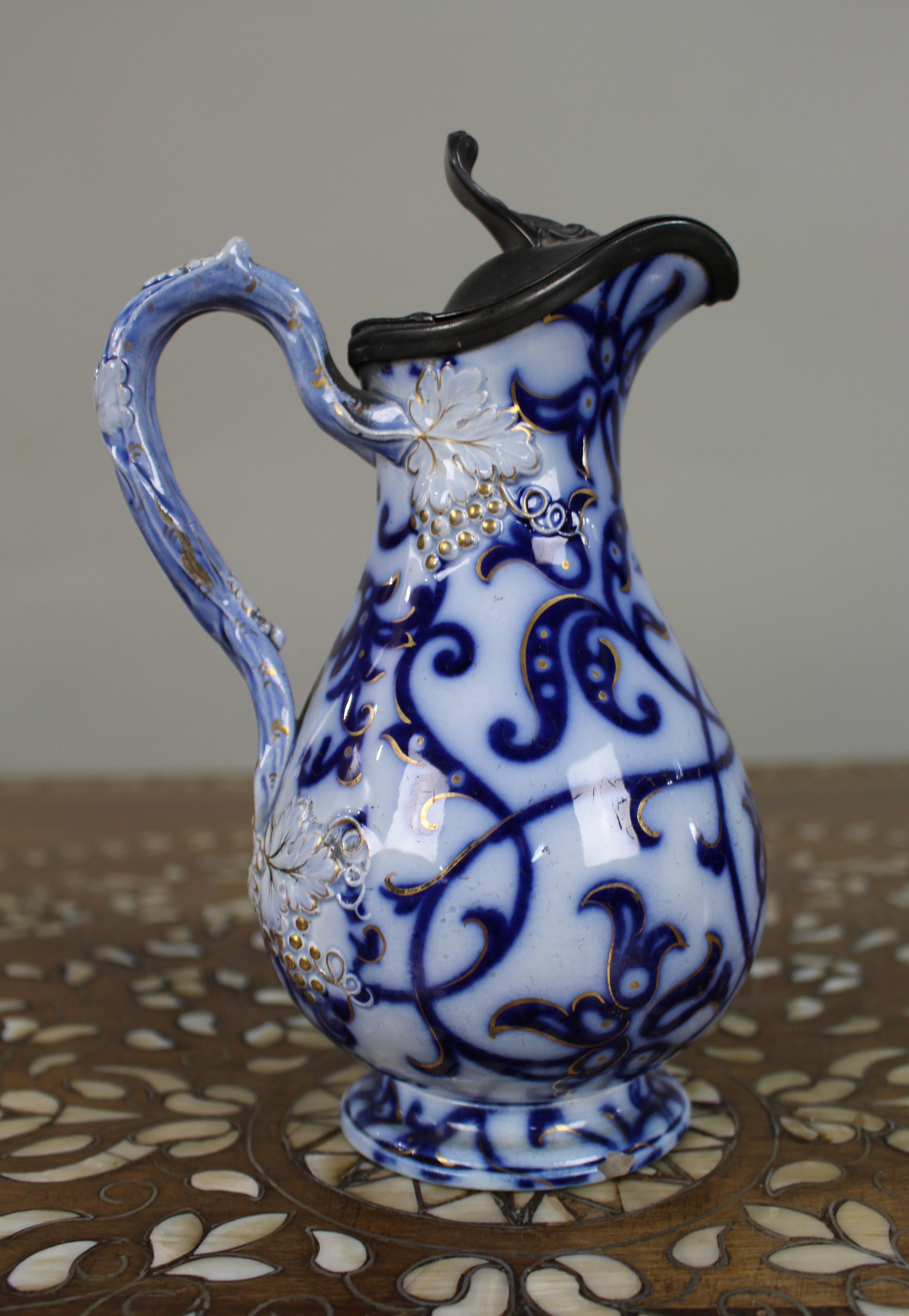 Cotto Brocca vittoriana Flow Blue modellata a rilievo con coperchio in peltro, 1850 ca. in vendita