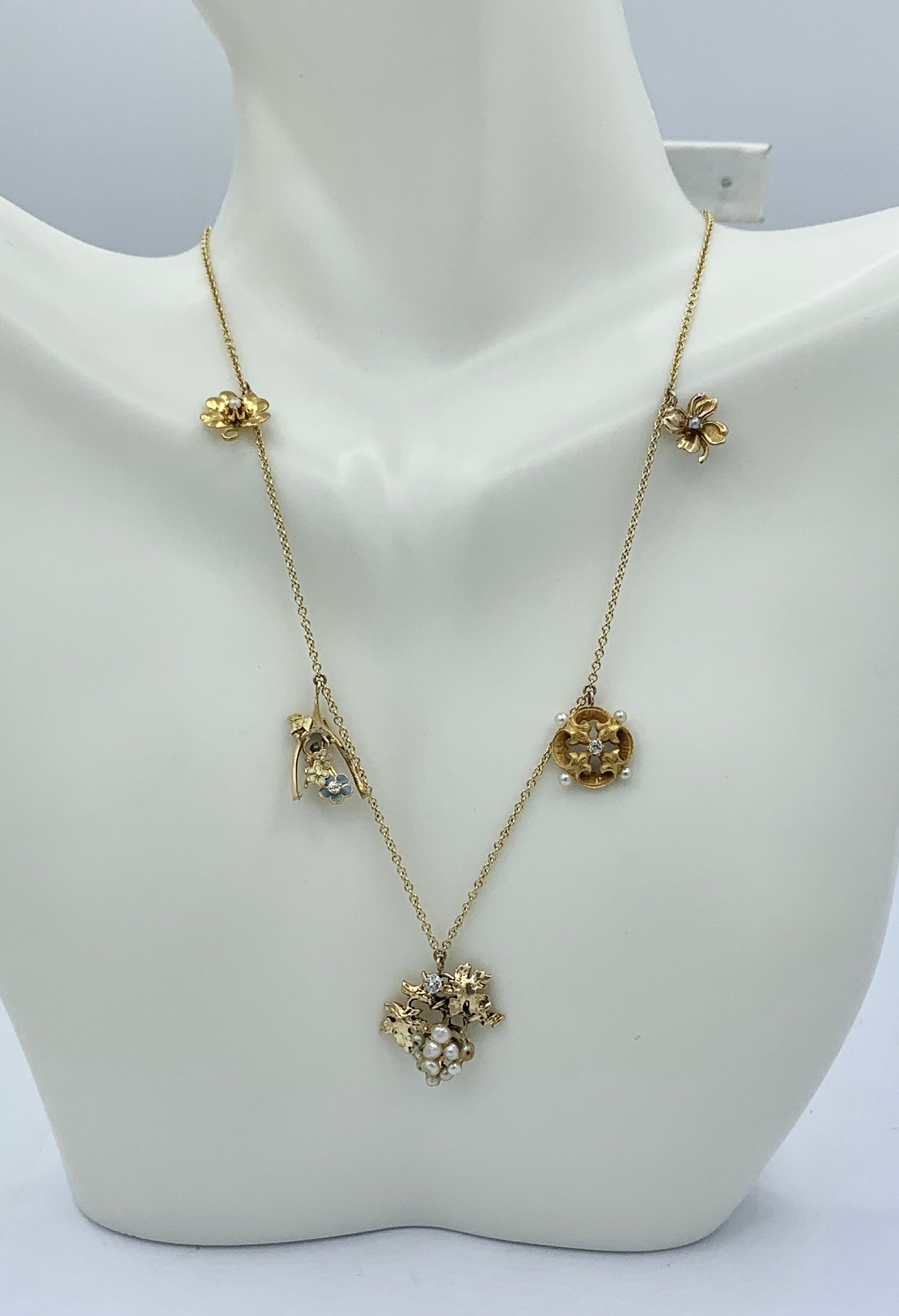 This is an absolutely gorgeous Victorian - Edwardian Flower Charm Necklace with Flowers adorned with Diamonds, Pearls, and Enamel.  The delicate romantic necklace is a reflection of the Victorian's love of flowers, the language of flowers, and