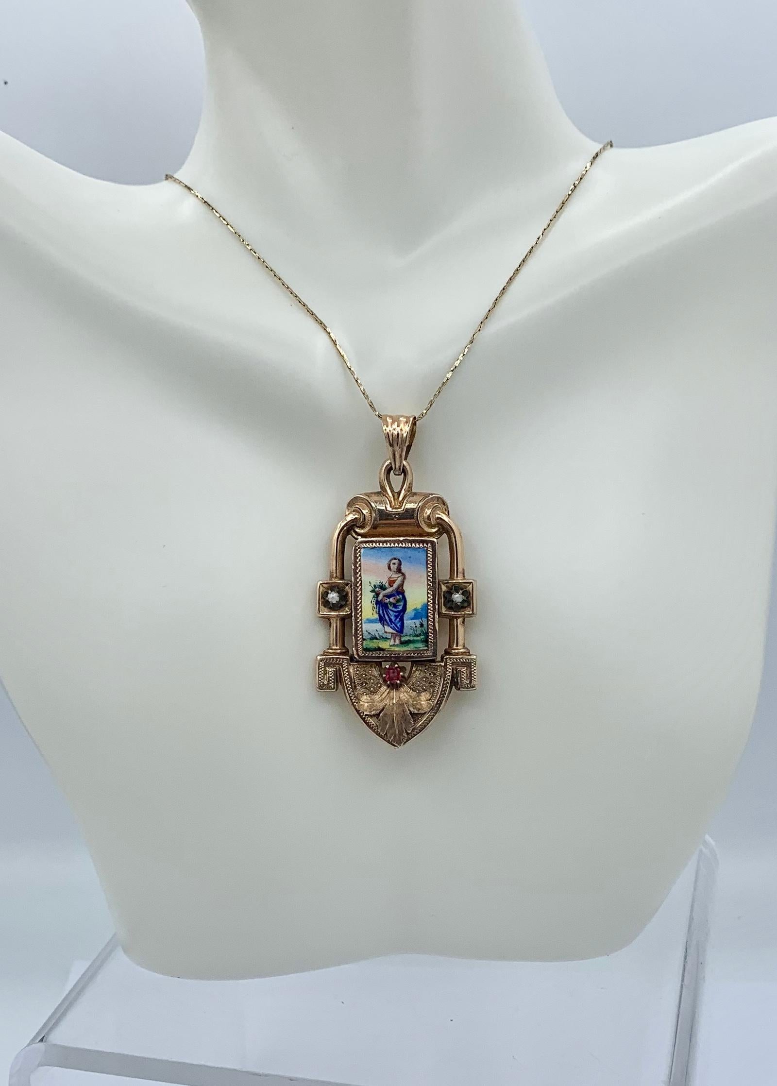 This is a rare and wonderful Victorian Enamel Ruby Pearl 14 Karat Gold Locket Pendant with an image of a woman carrying flowers. The romantic and charming image is done in enamel with gorgeous colors and details.  The maiden carries flowers