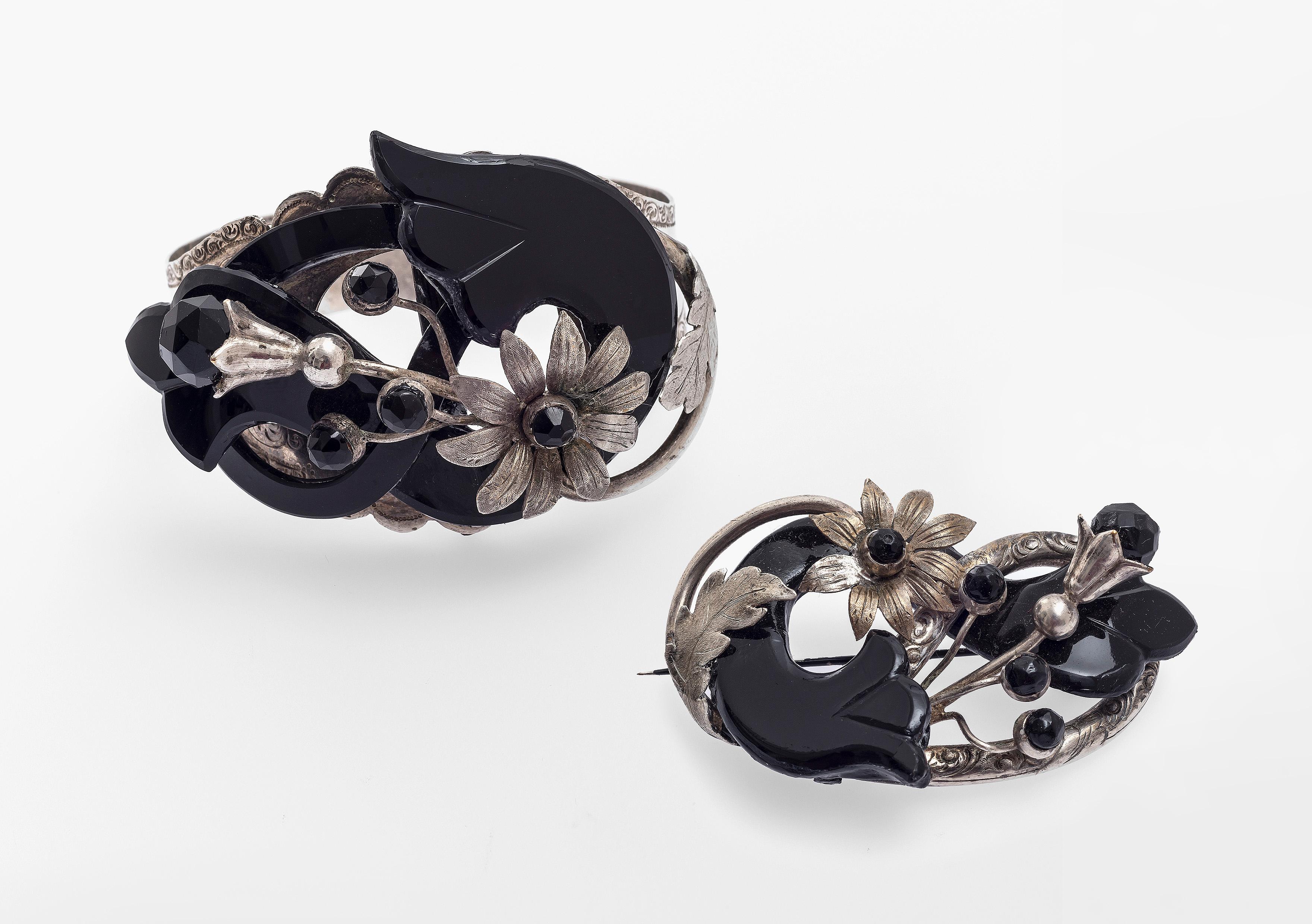 Sehr stilvolles Armband mit passender Brosche aus Silber und Onyx in der Originalschatulle. das Design der Demi Parure zeigt verschiedene Arten von Blumen, Blütenknospen und Blättern, ausgeführt in geschnitztem Onyx und montiert in fein graviertem
