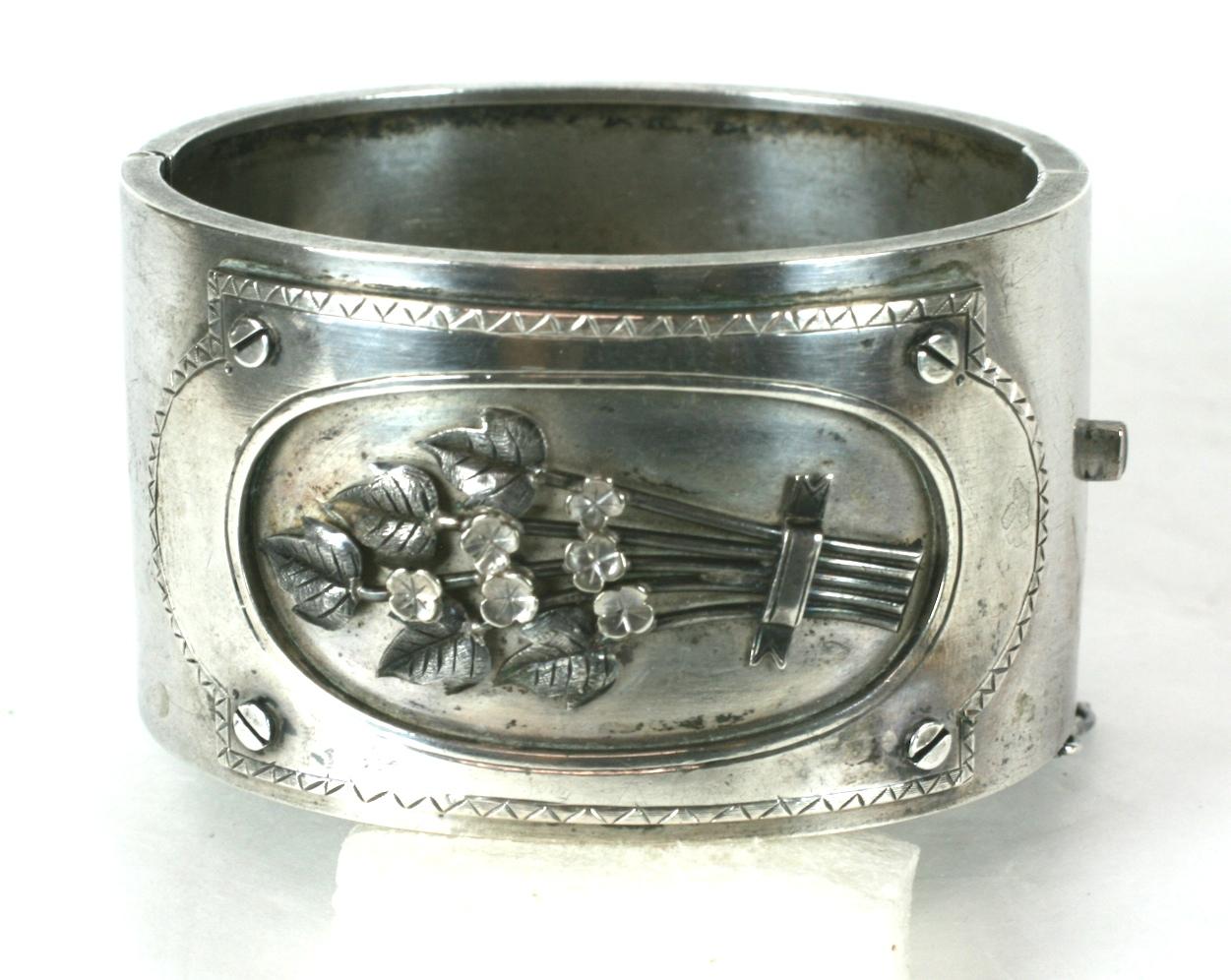 Charming Victorian Silver Cuff with central cartouche of flowers. Unusual design depicts a panel which is screwed onto the cuff like a picture frame with a bouquet of elaborately detailed flowers within. 
1880's USA. Silver, unmarked. Monogram 