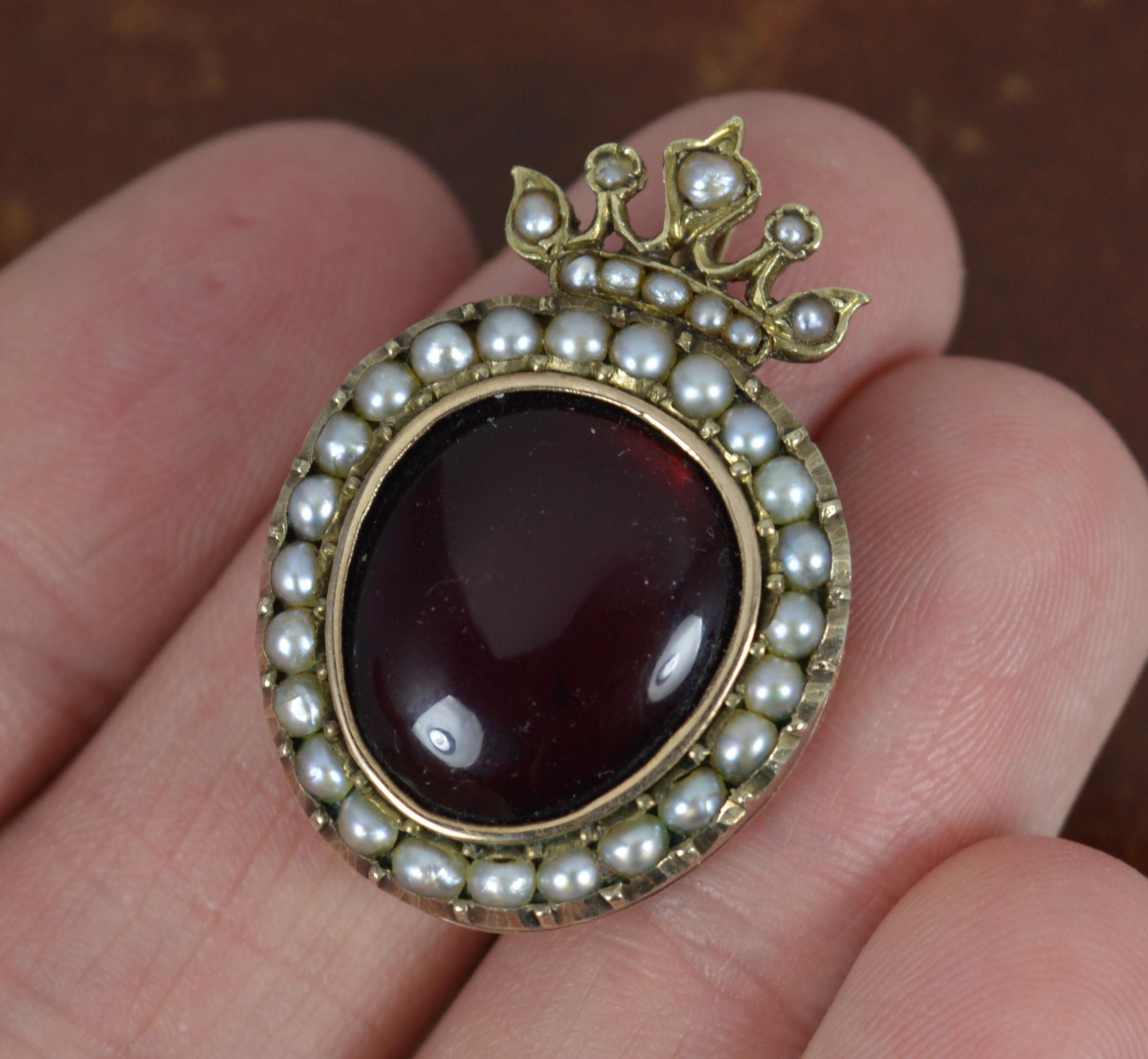 A superb mid Victorian period pendant. Circa 1860.
Solid 15 carat rose gold example.
Designed with a 'heart' base, set with a large, foiled back garnet cabochon to centre with a full border of seed pearls surrounding. Set with further seed pearls