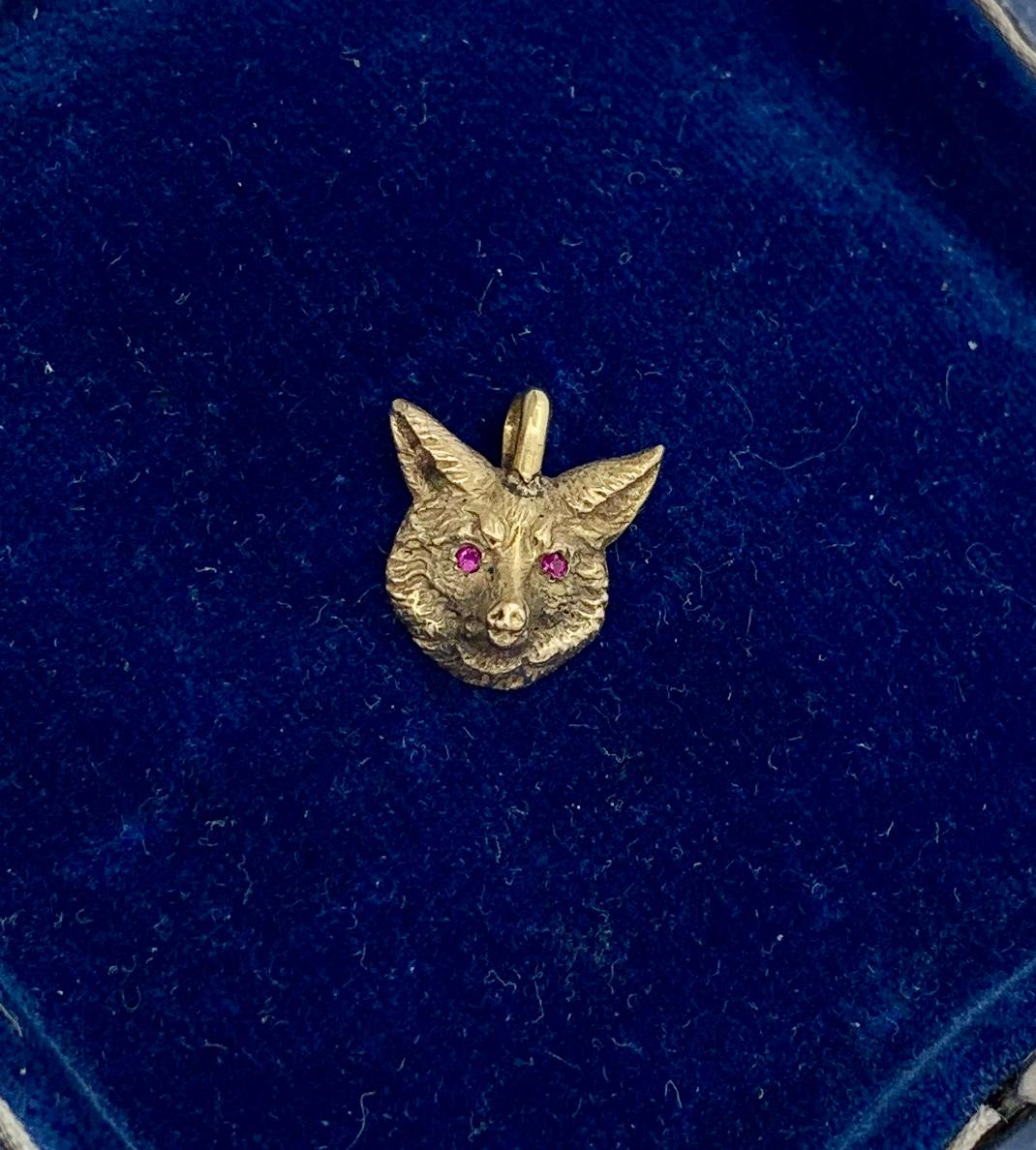 A wonderful antique Belle Epoque, Victorian pendant with a beautifully modeled Fox head in 14 Karat Gold with two round faceted Ruby eyes.  We love our antique animal jewelry and this one has such stunning design.   The engraved gold work creates a