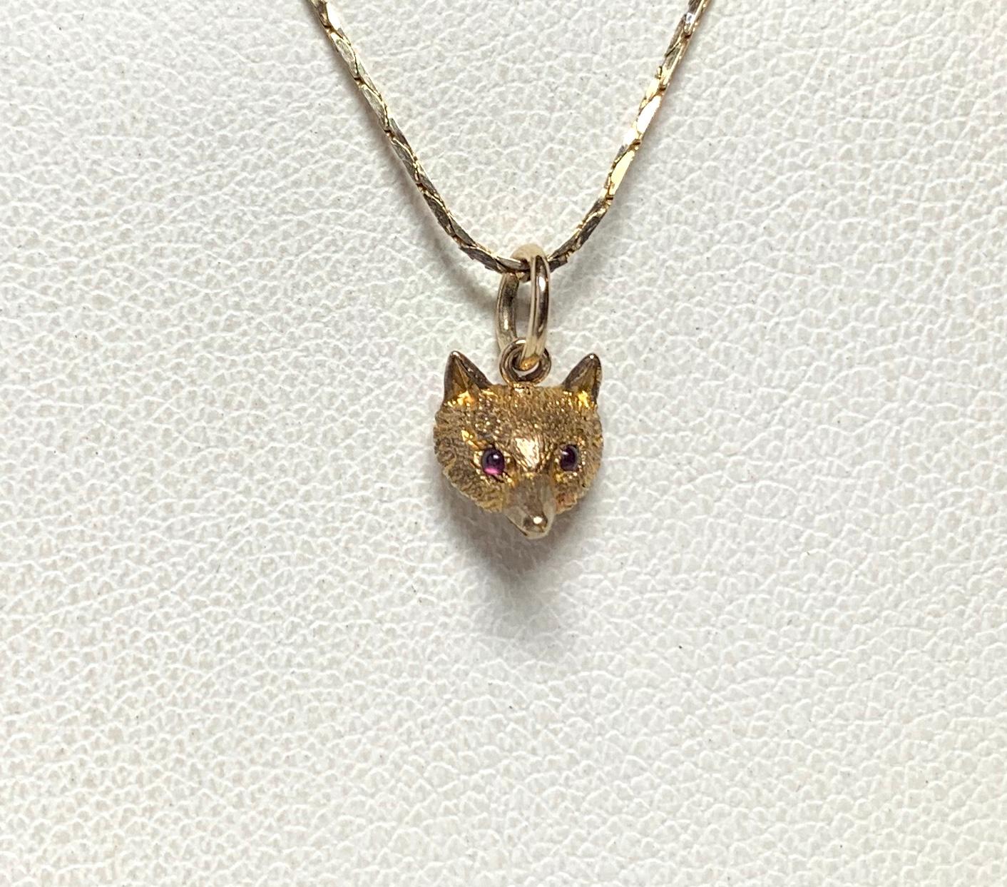 A wonderful antique Belle Epoque, Victorian pendant with a beautifully modeled Fox head in 9 Karat Gold with two Ruby eyes.  We love our antique animal jewelry and this one has such stunning design.   The engraved gold work creates a magnificent