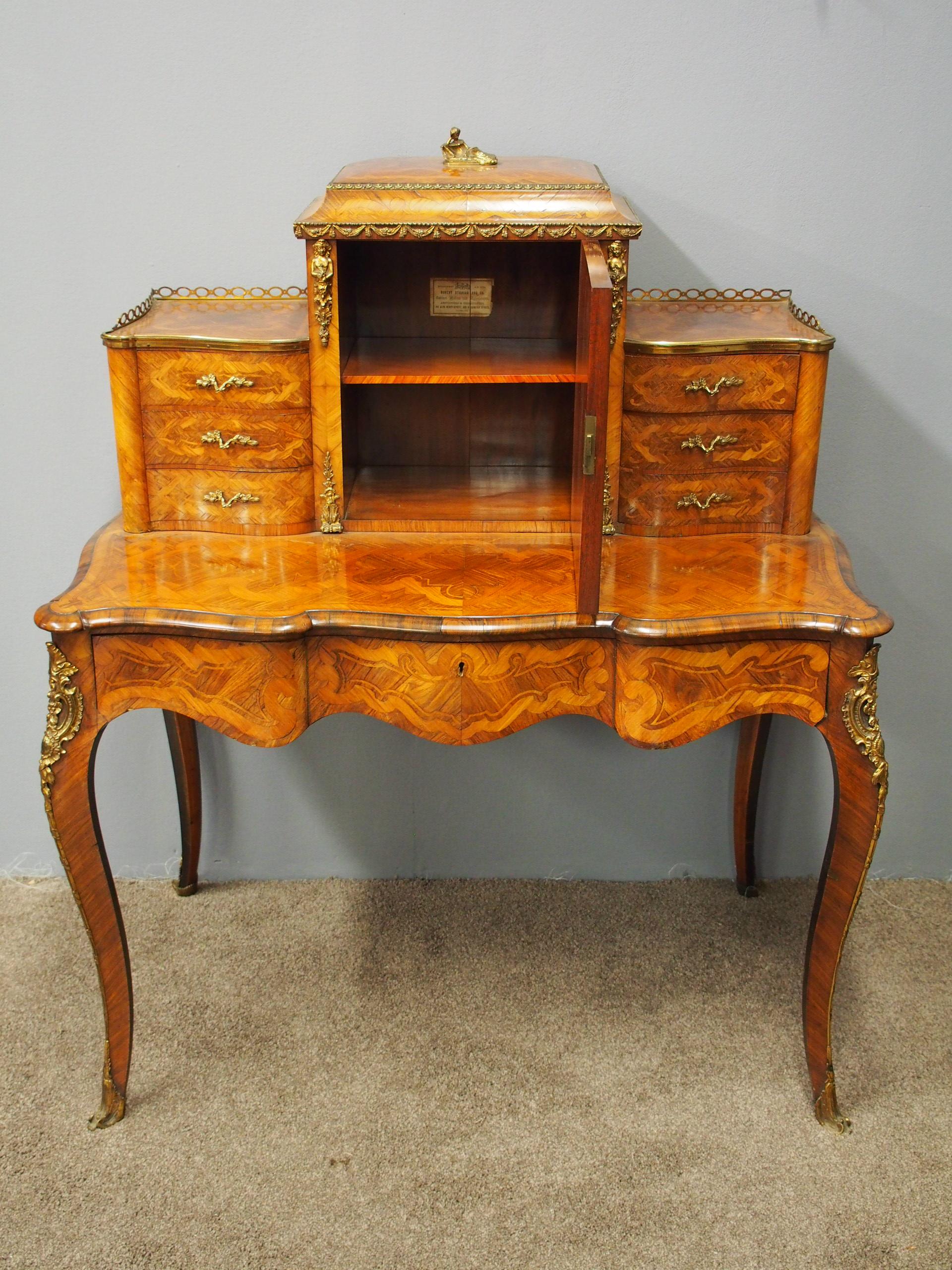 Exhibition quality French Bonheur du jour, circa 1870. With domed top surmounted by gilded figure, and a surrounding fretwork around a combination of fine beaded marquetry and parquetry. The front, central door has a Sevres style panel, and inside