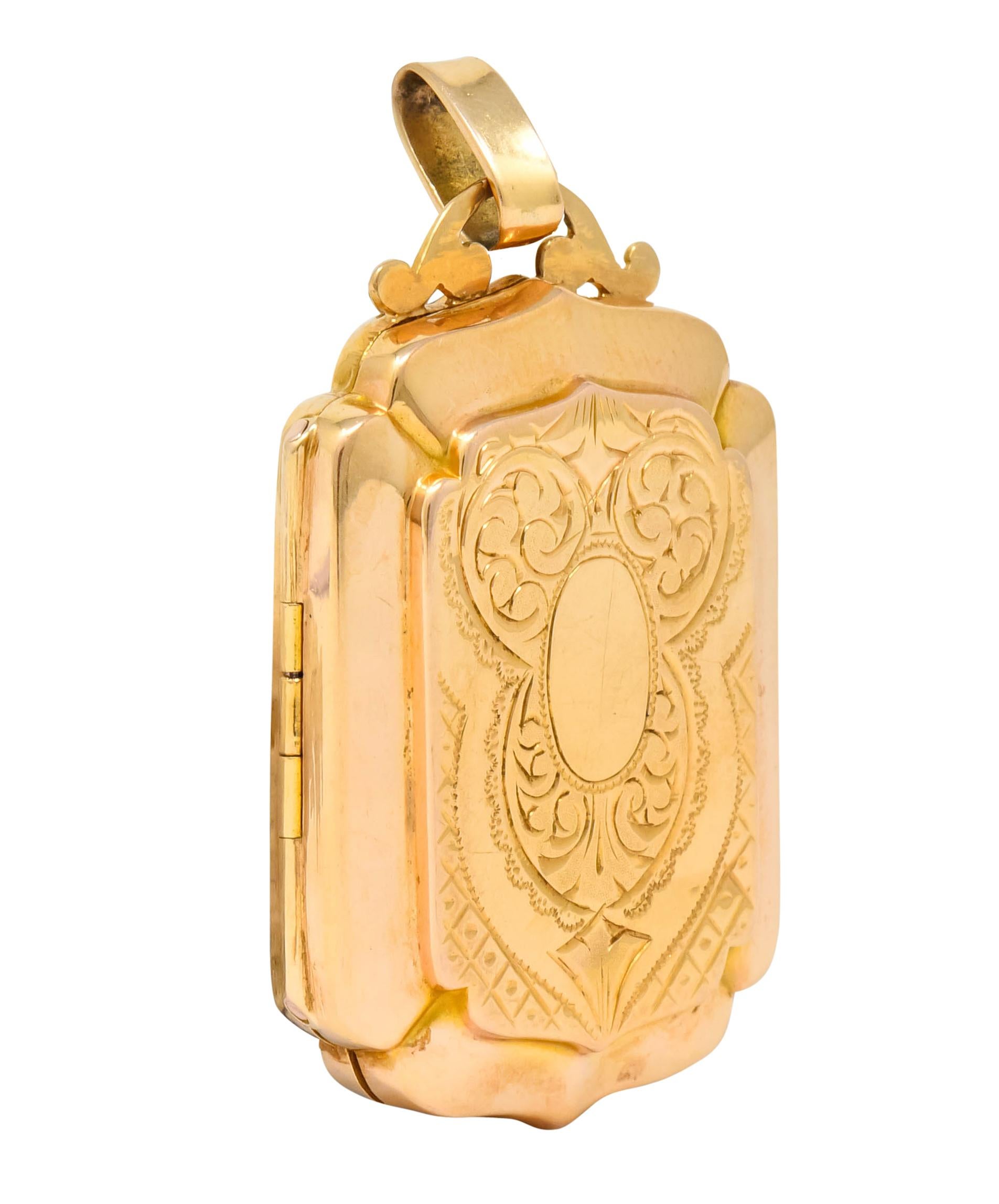Pendant designed as an ornate rectangular locket with a scrolled detail for oval bale

Front deeply engraved with scrolled lace motif while back is deeply engraved with dotted floral motif with zig-zagged frame

Opens on a hinge to reveal two