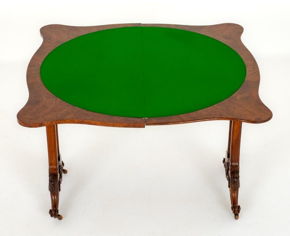 Victorian Burr Walnut Card table.
Circa 1860
This Table is Raised upon Shaped Supports with Carved Knees and Carved Toes.
The Supports Feature Pierced Fret Work.
The Top of the Table is of a Serpentine Form and Opens to Reveal a Baize Playing