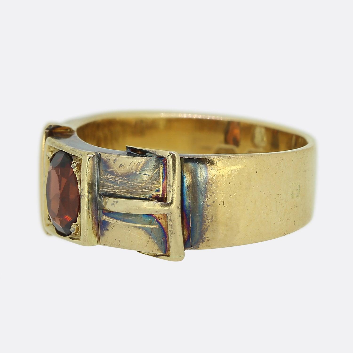 Aquí tenemos un anillo de oro amarillo de 18 ct de la época victoriana. Esta pieza antigua tiene forma de hebilla de cinturón y alberga un diamante de talla antigua y un granate espesartita de talla oval. El anillo está totalmente marcado en
