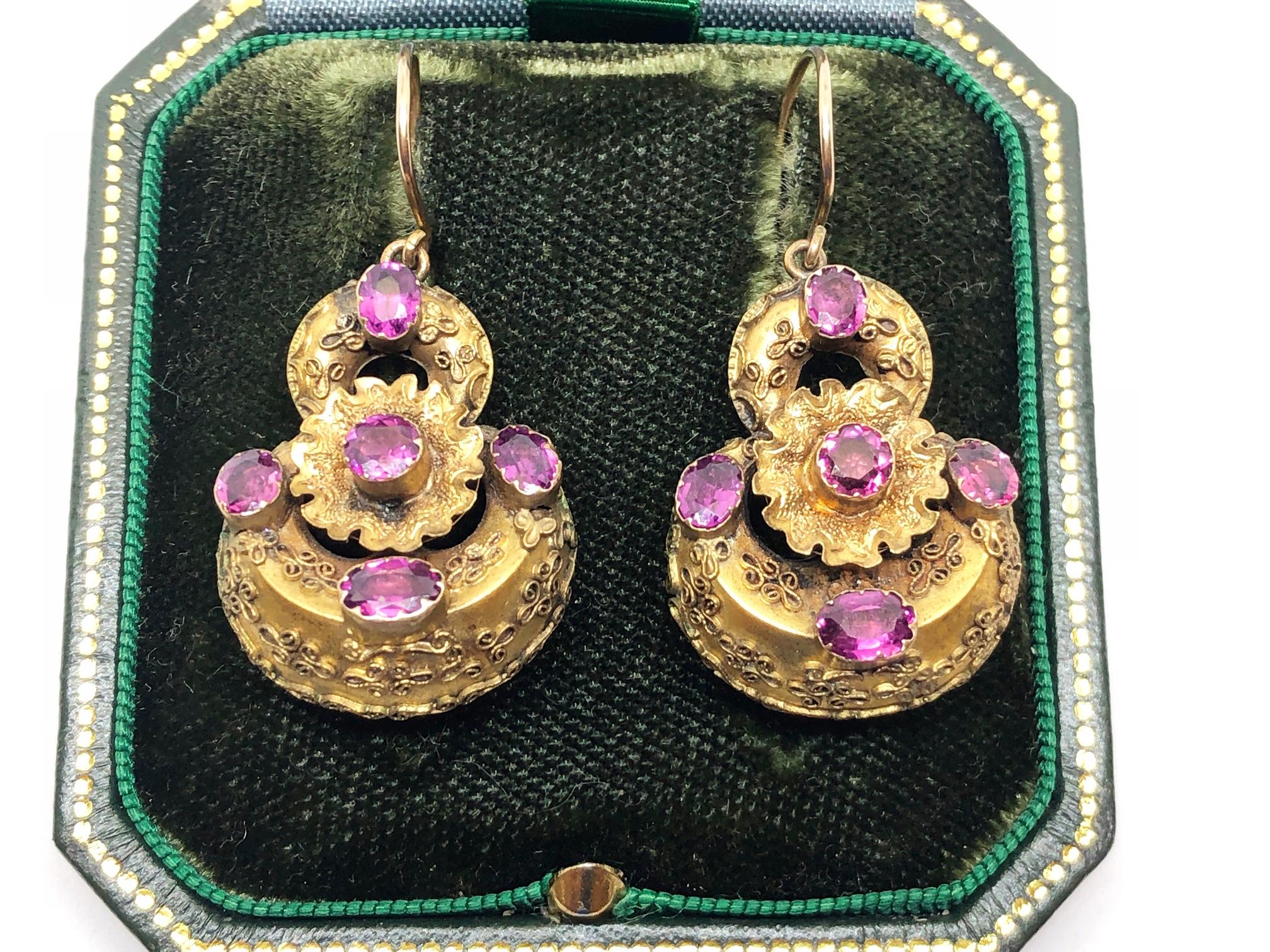 A pair of Victorian, gold earrings, with Etruscan style cannetille work to the body, each earring set with five, oval, almandine garnets, on hook fittings, circa 1870.