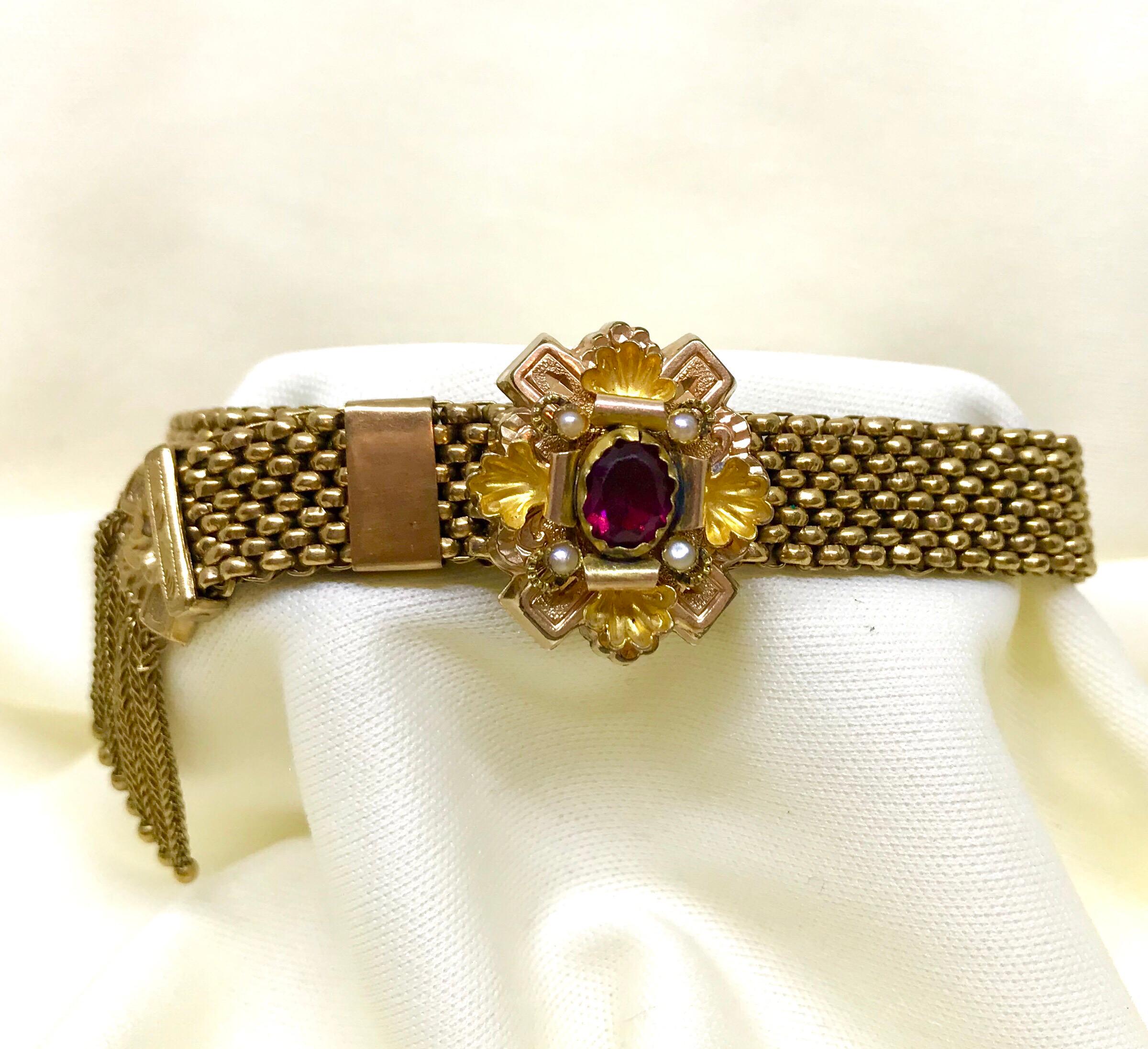 Antique Victorian garnet and pearl gold filled mesh bracelet with a foxtail chain tassel.  The ornately designed top piece is bezel set with an oval faceted garnet and embellished with four small pearls.  When the slide is opened all the way the