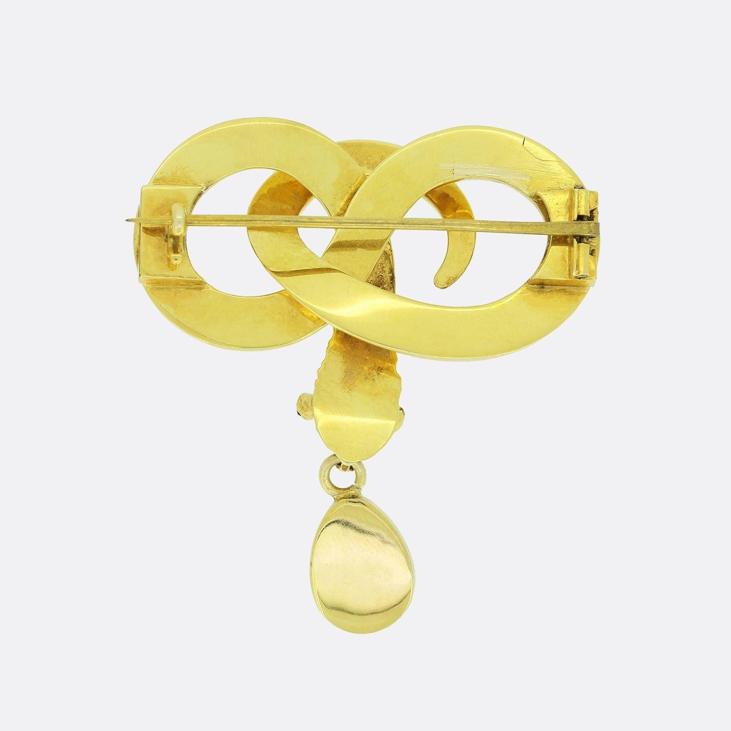 Il s'agit d'une broche ancienne en forme de serpent. Fabuleusement travaillée et enroulée en or jaune 15ct pour représenter le symbole de l'infini, cette pièce est sertie de turquoises sur la tête et de grenats pour les yeux, avec un magnifique