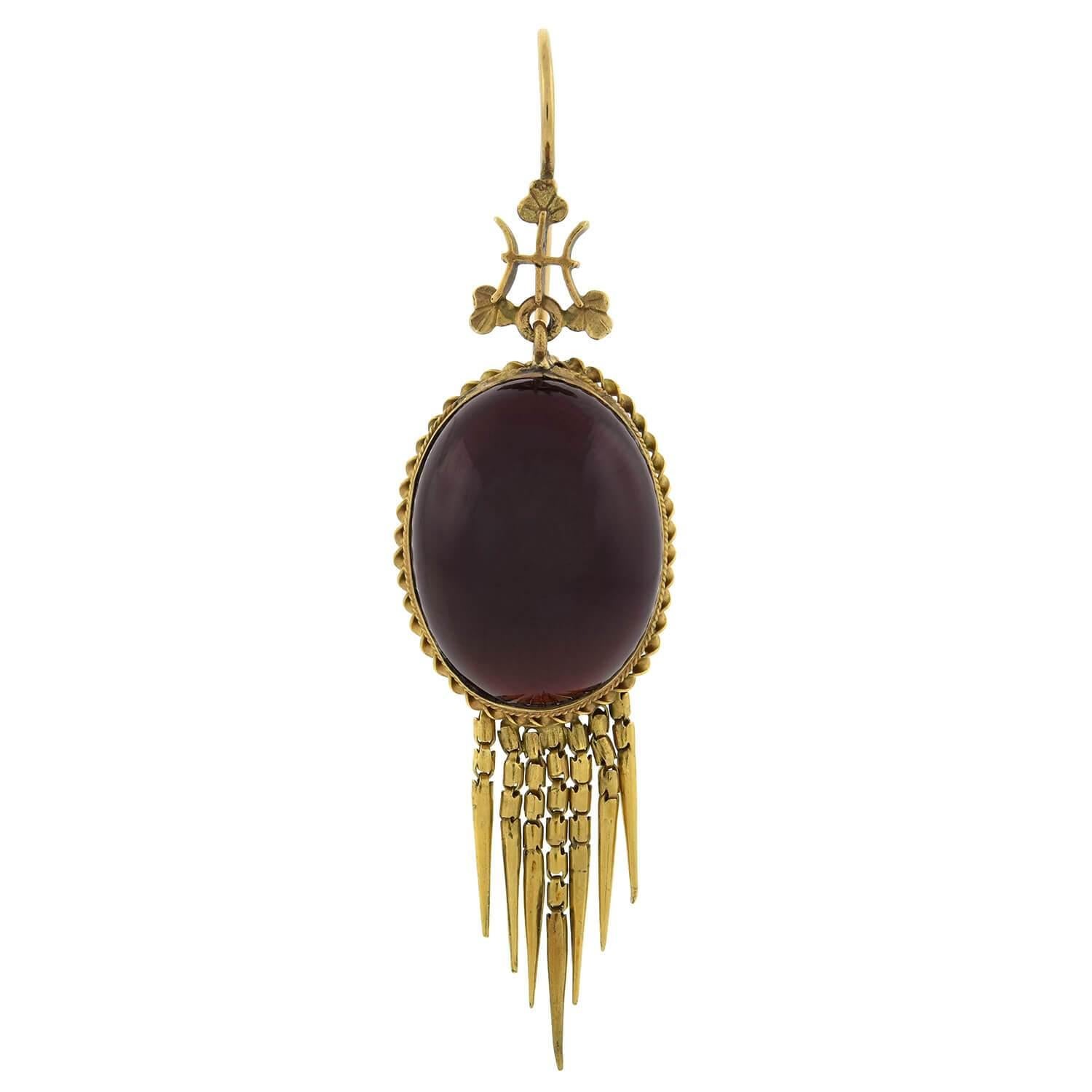An absolutely gorgeous pair of garnet earrings from the Victorian (ca1880s) era! Crafted in rich 15kt yellow gold, each of these dramatic earrings holds a large open-backed cabochon garnet stone at the center. The garnet rests in a gold bezel which