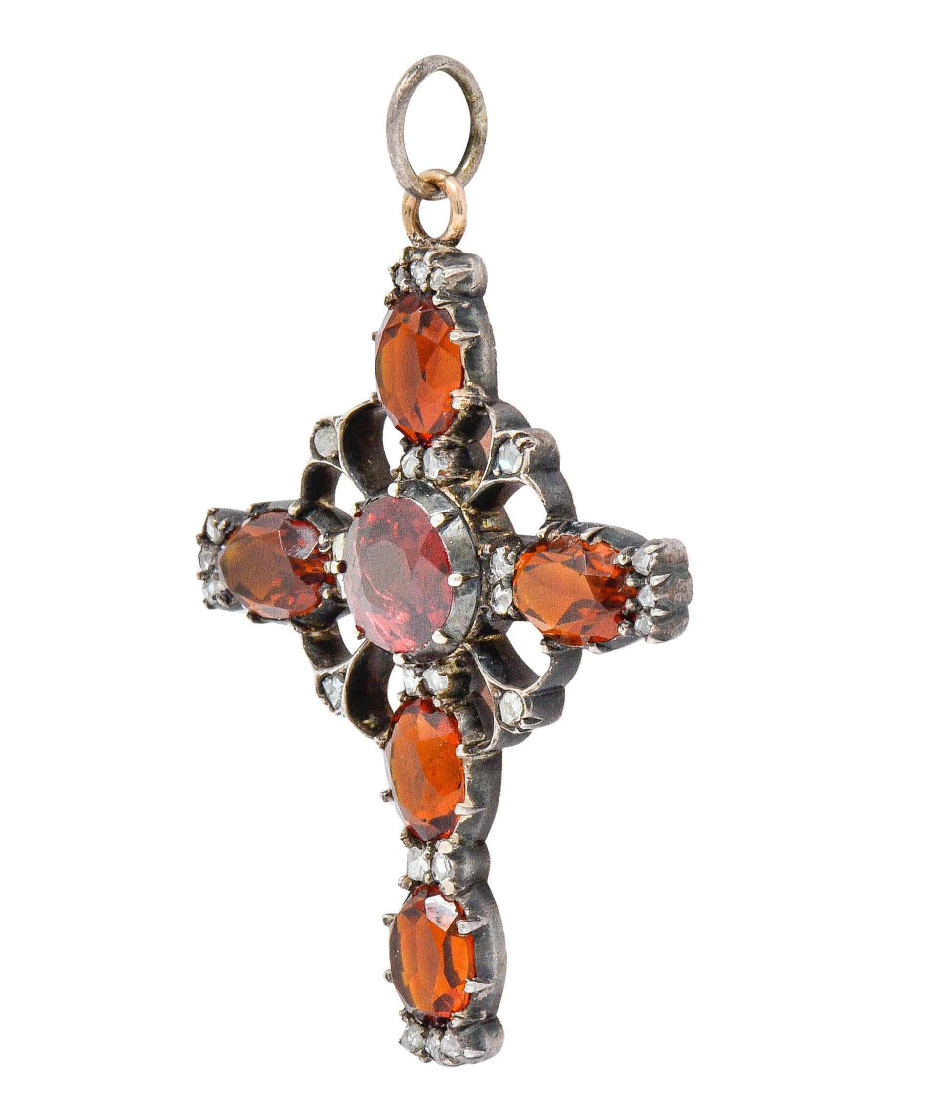 Designed as an ornate cross with a circular center and gemmed extensions

Centering a 8.3 mm round cut garnet, transparent, with medium-light red color

Surrounded by oval cut citrine measuring approximately 8.0 x 6.0 mm

Very well-matched in smokey