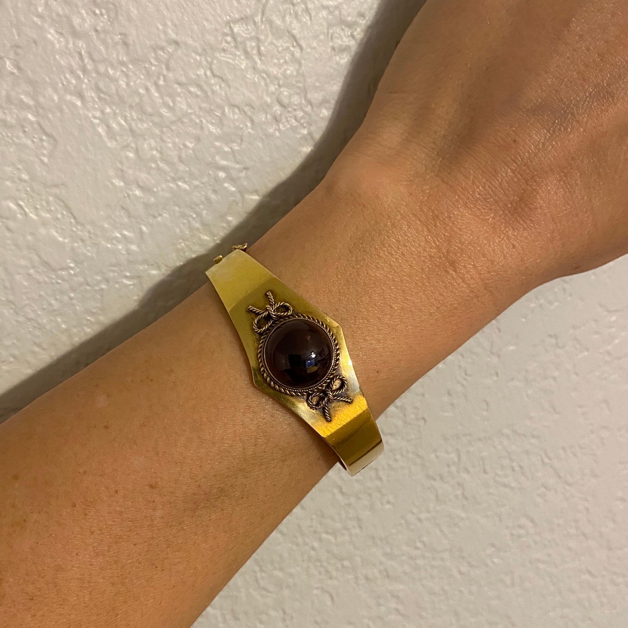 Simply Beautiful, Elegant and finely detailed Victorian Garnet Bangle Cuff Bracelet. Hand crafted in 18 Karat yellow Gold, center set with a cabochon Garnet, surrounded by twist rope bow design. Approx. dimensions: 2.5”w x 0.92”h x 1.4”d, inner cuff