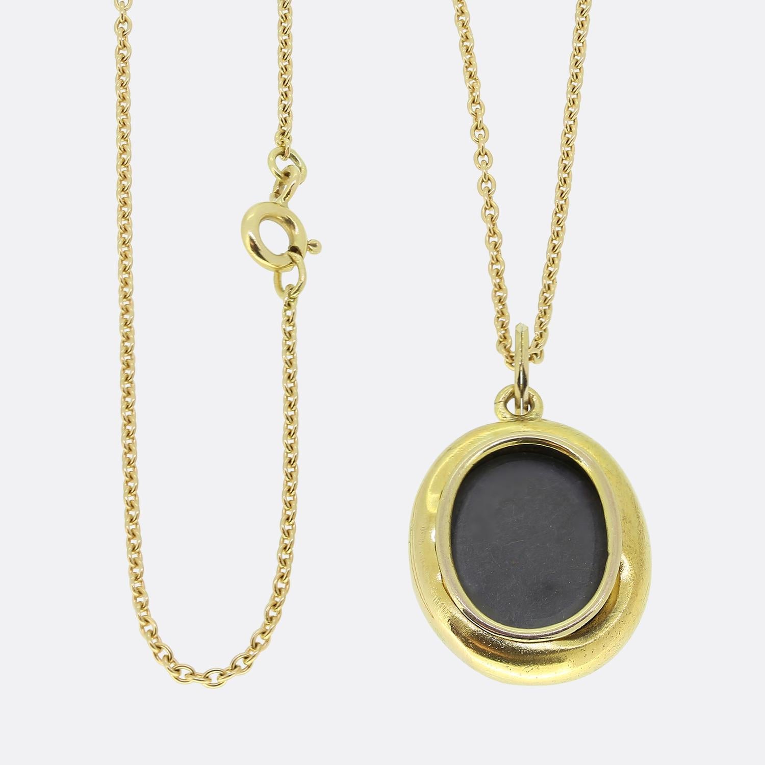 Here we have a wonderful garnet set locket necklace. This antique pendant has been crafted from 15ct yellow gold into an oval shape and set with three oval shaped almandine garnets. These focal gemstones sit slightly risen atop an ornately engraved